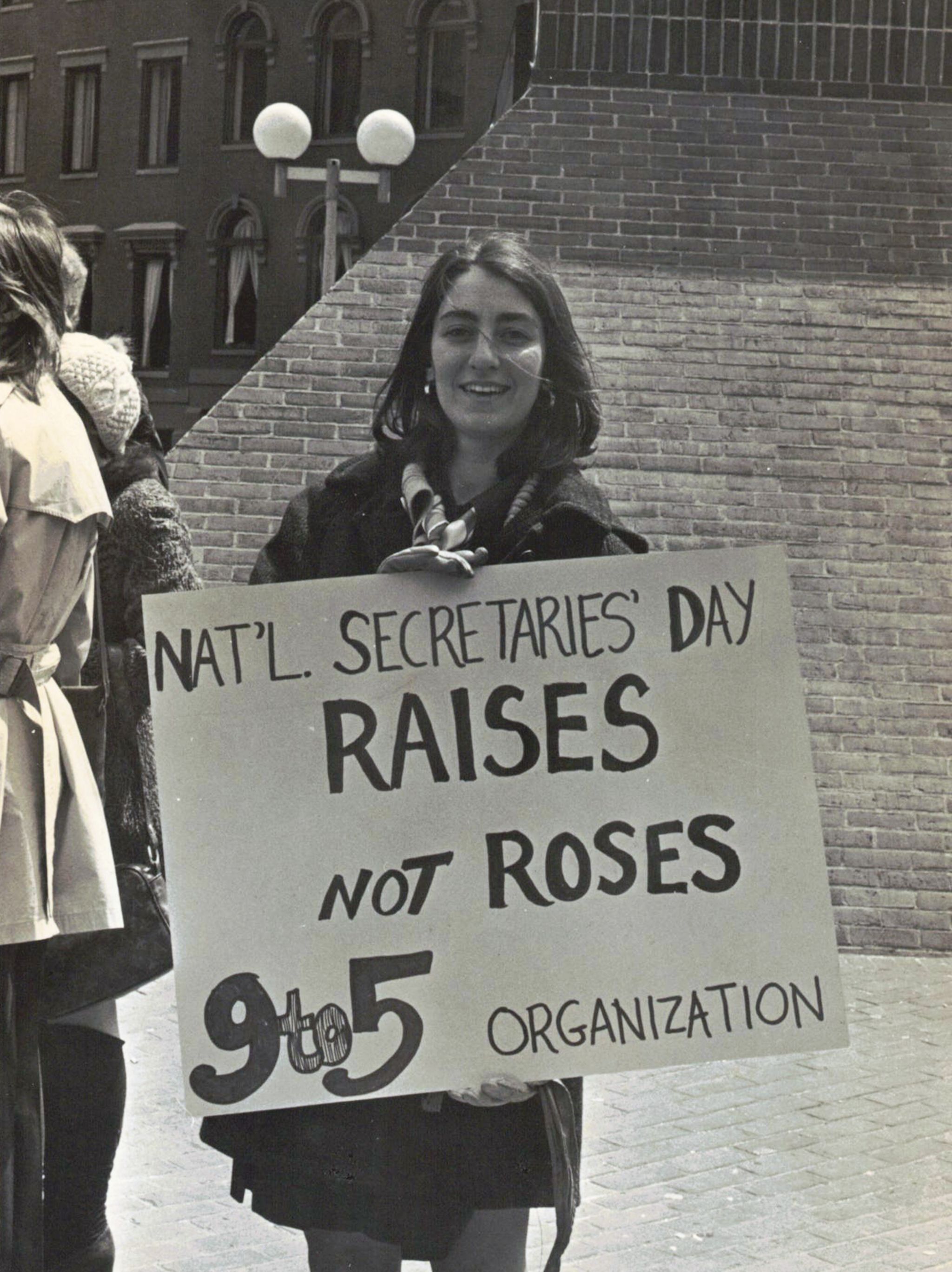 Karen Nussbaum at the first National Secretaries' Day protest in Boston 1974, carrying a placard that says Raises not Roses