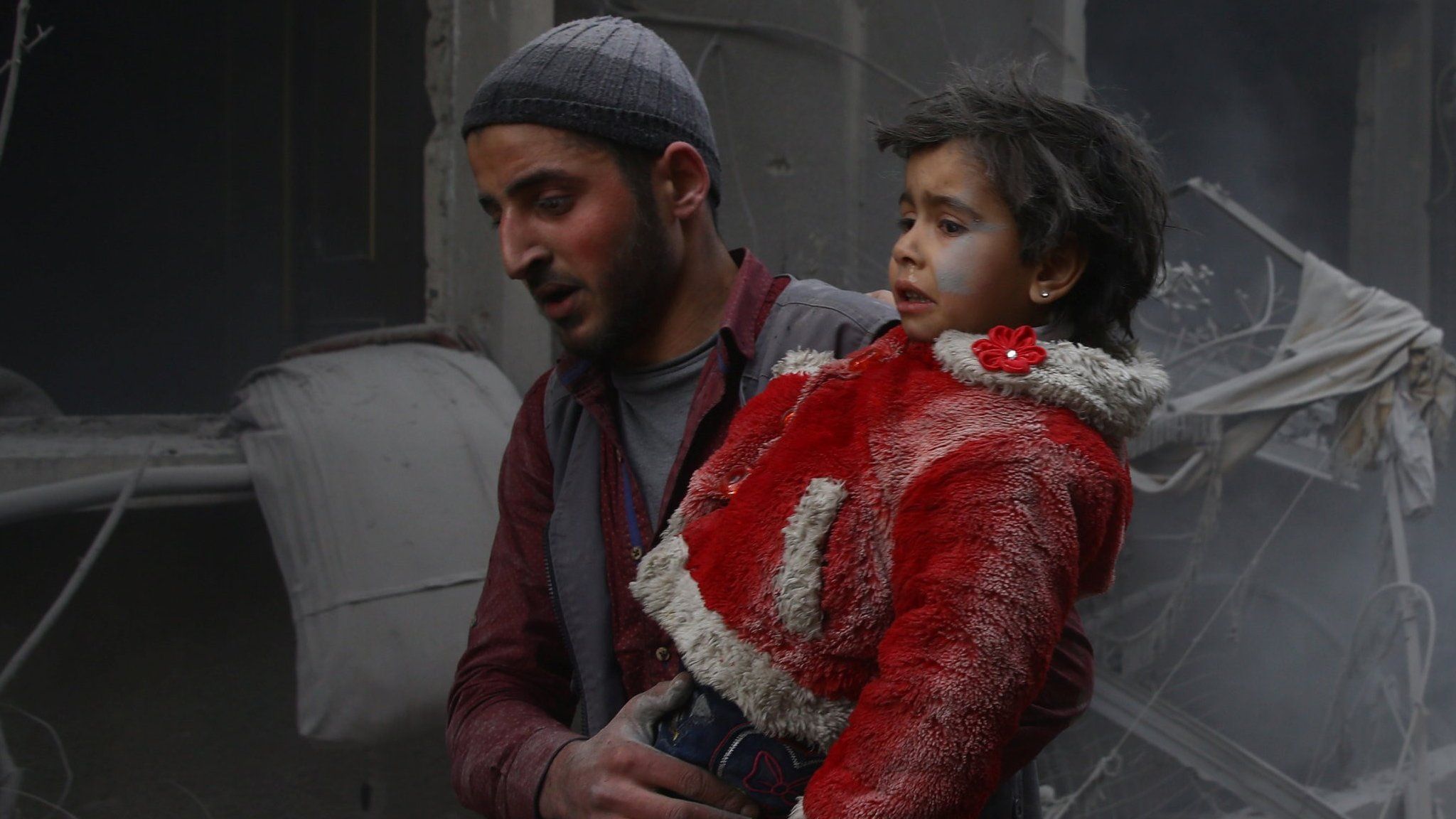 A girl is carried by a rescuer after a reported government air strike on the town of Douma, in the rebel-held Eastern Ghouta near Damascus, Syria (7 February 2018)