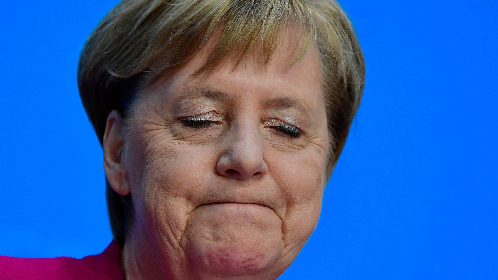 German Chancellor Angela Merkel closes her eyes as she gives a press conference on 29 October