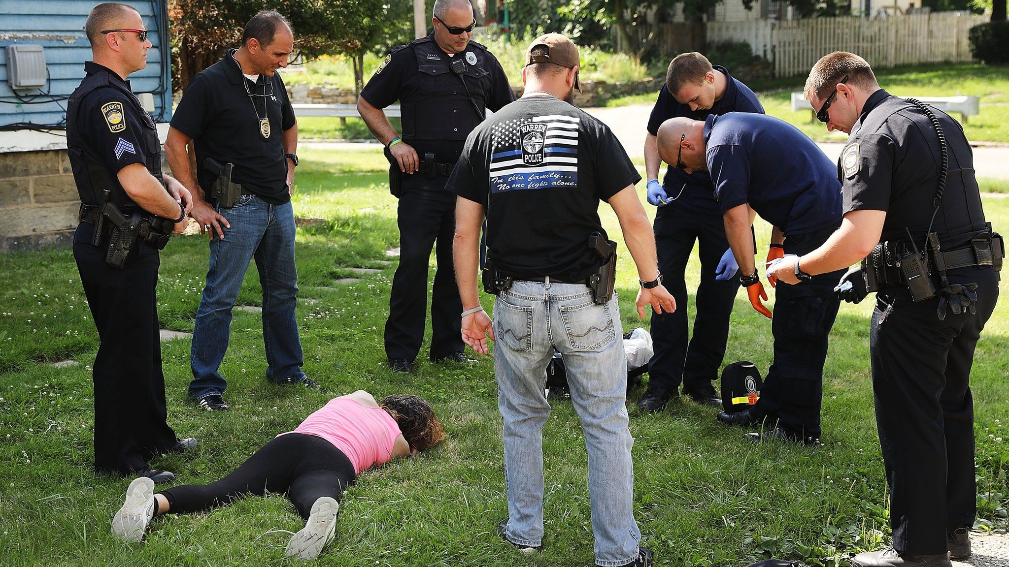 Medical workers and police treat a woman who has overdosed on heroin in Warren, Ohio, on 14 July 2017