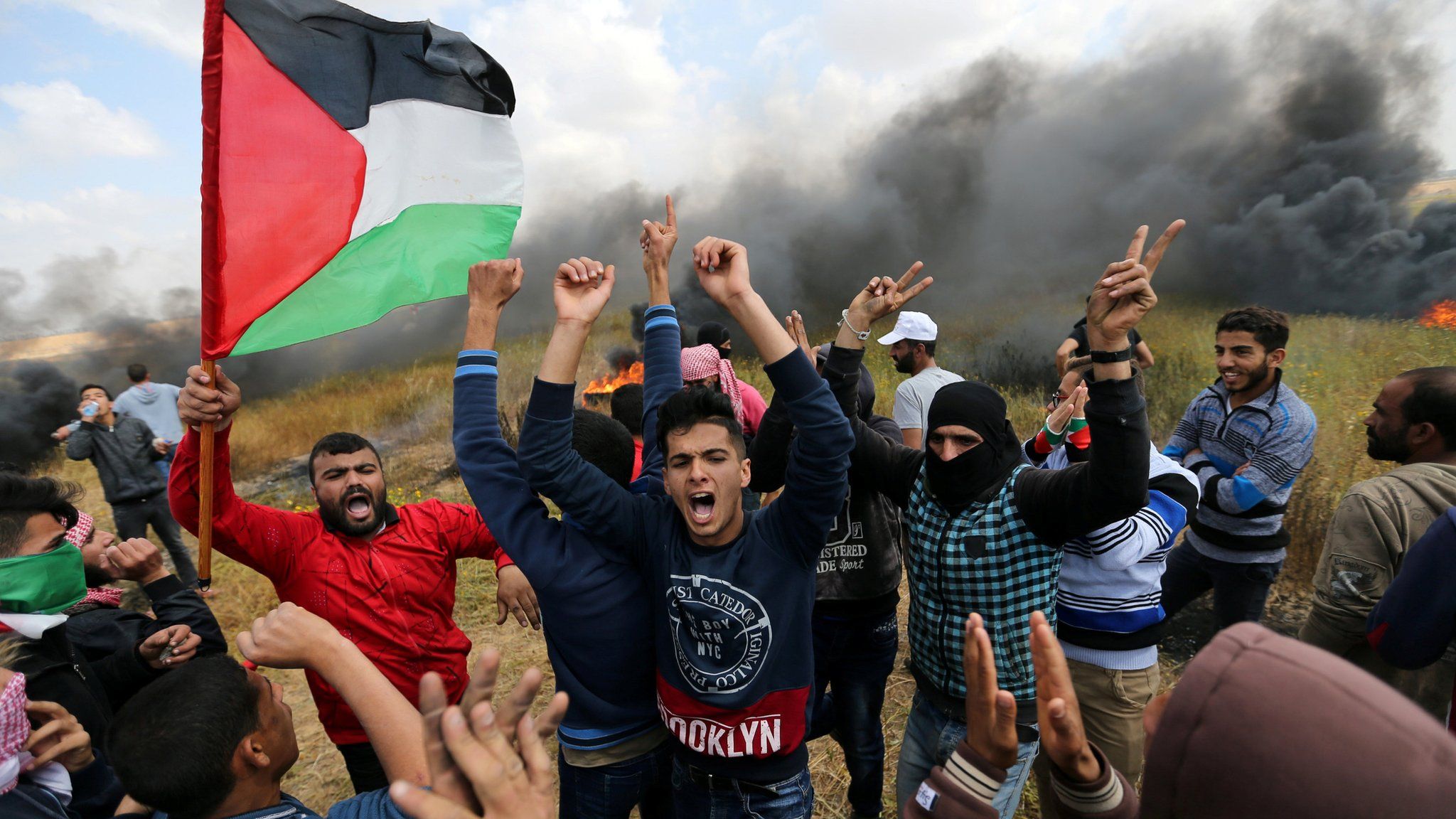 Palestinians shout during clashes with Israeli troops, during a protest along the Israel border with Gaza, March 30 2018