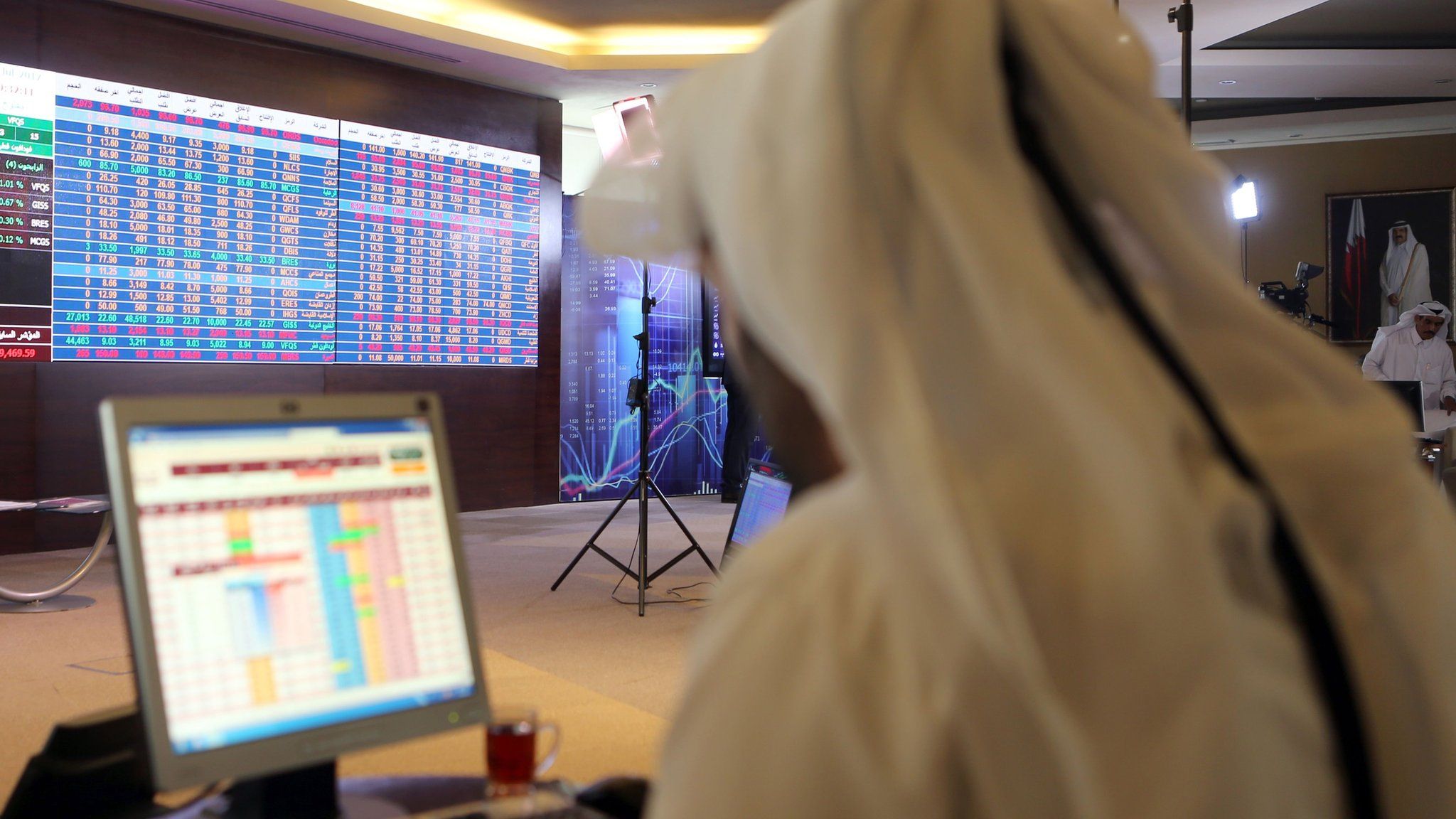 File photo showing a Qatari trader following the stock market at the Qatari stock exchange in Doha (31 July 2017)