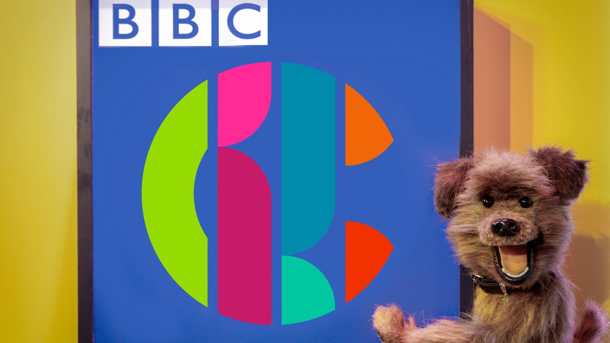 The Hacker T Dog puppet and the CBBC logo