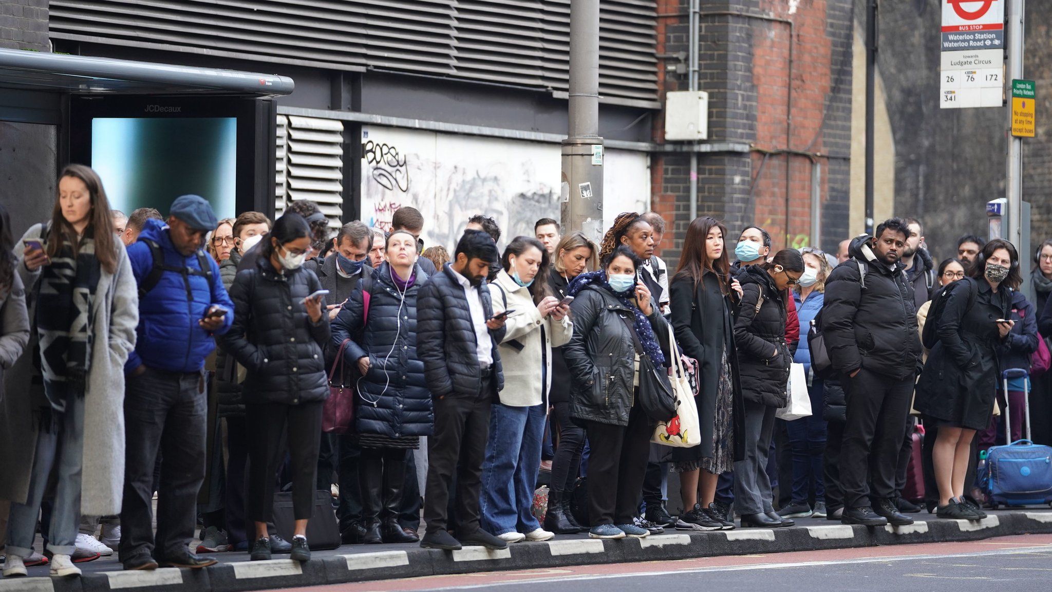 People wait for buses at Waterloo station in London during the Tube strike