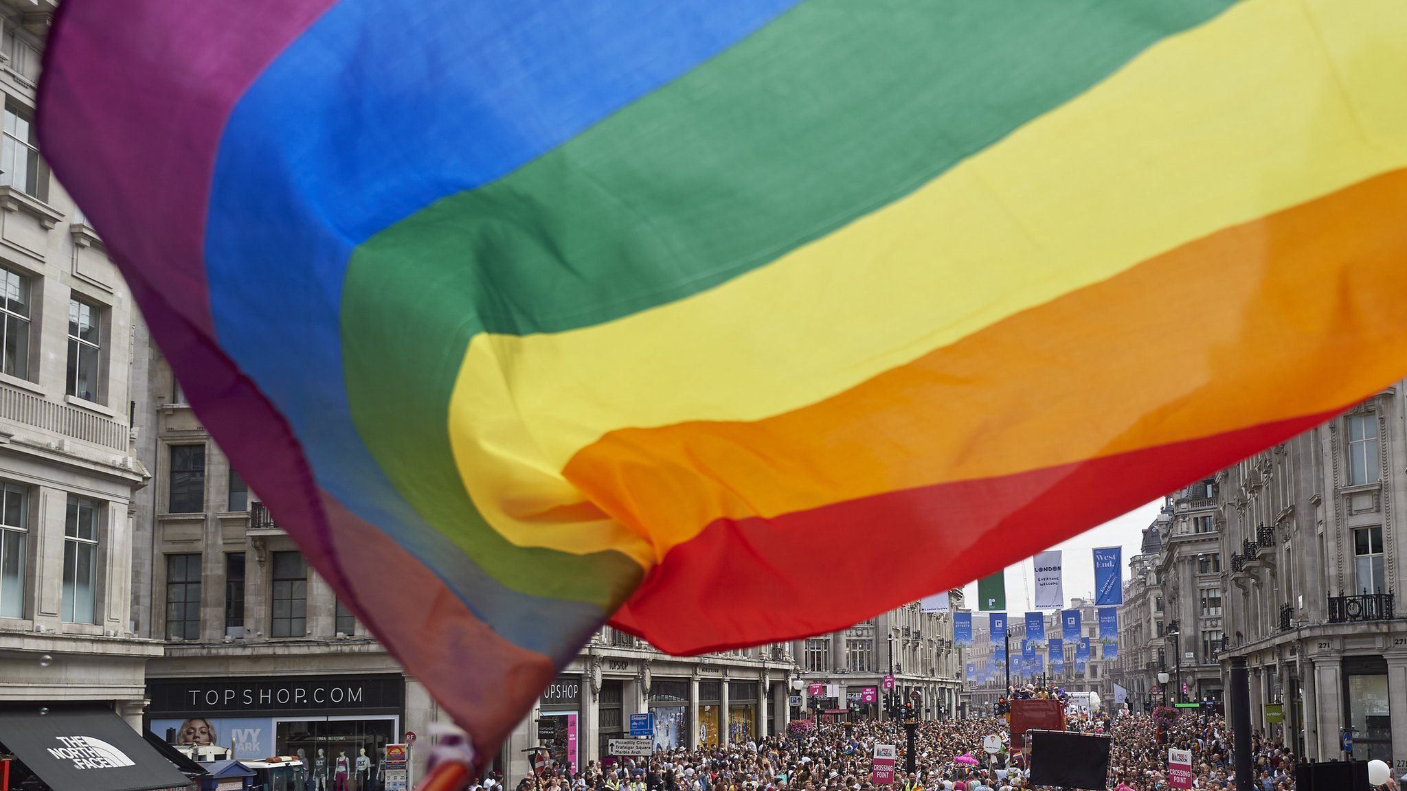 a rainbow flag flies above London's pride parade