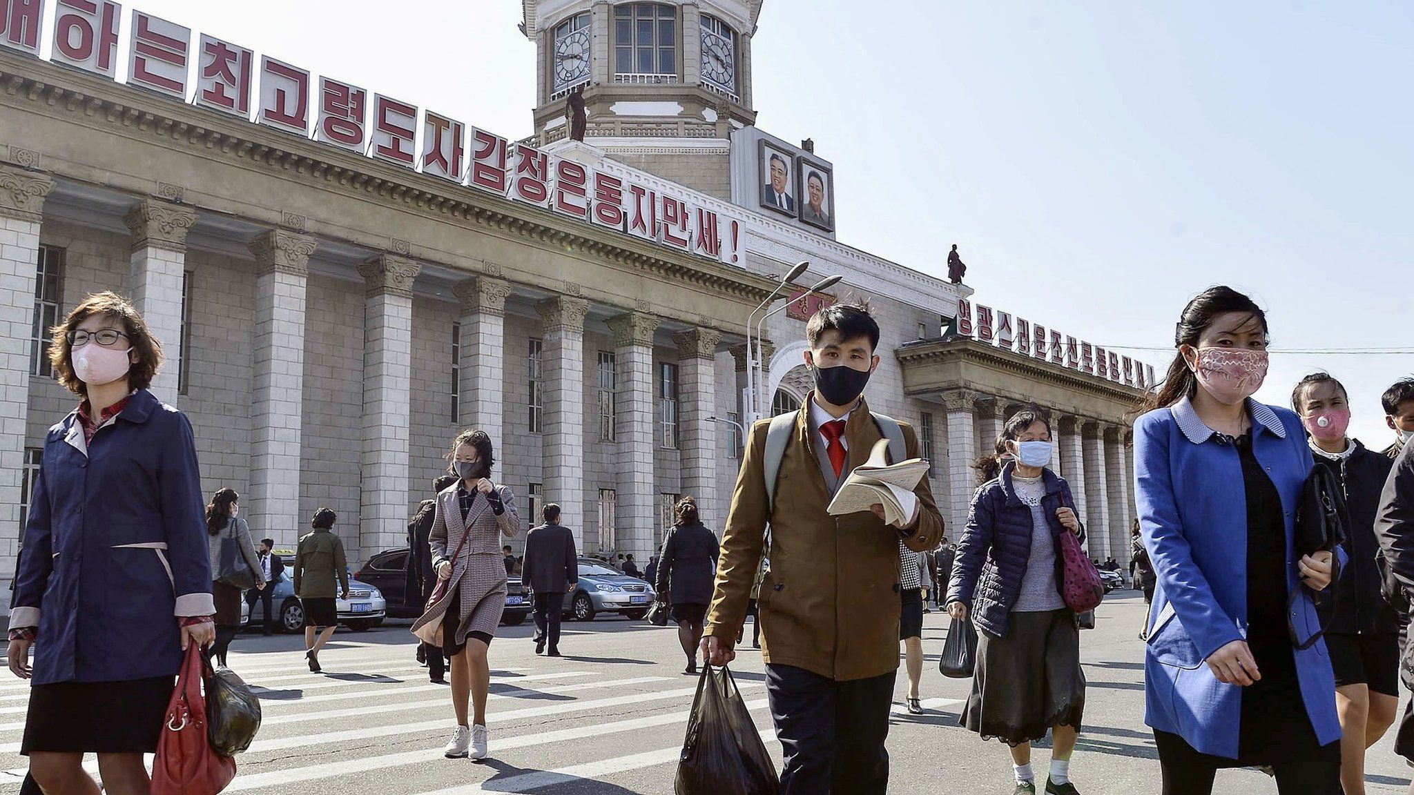 People wear face masks in front of Pyongyang Station in Pyongyang, North Korea (27 April 2020)