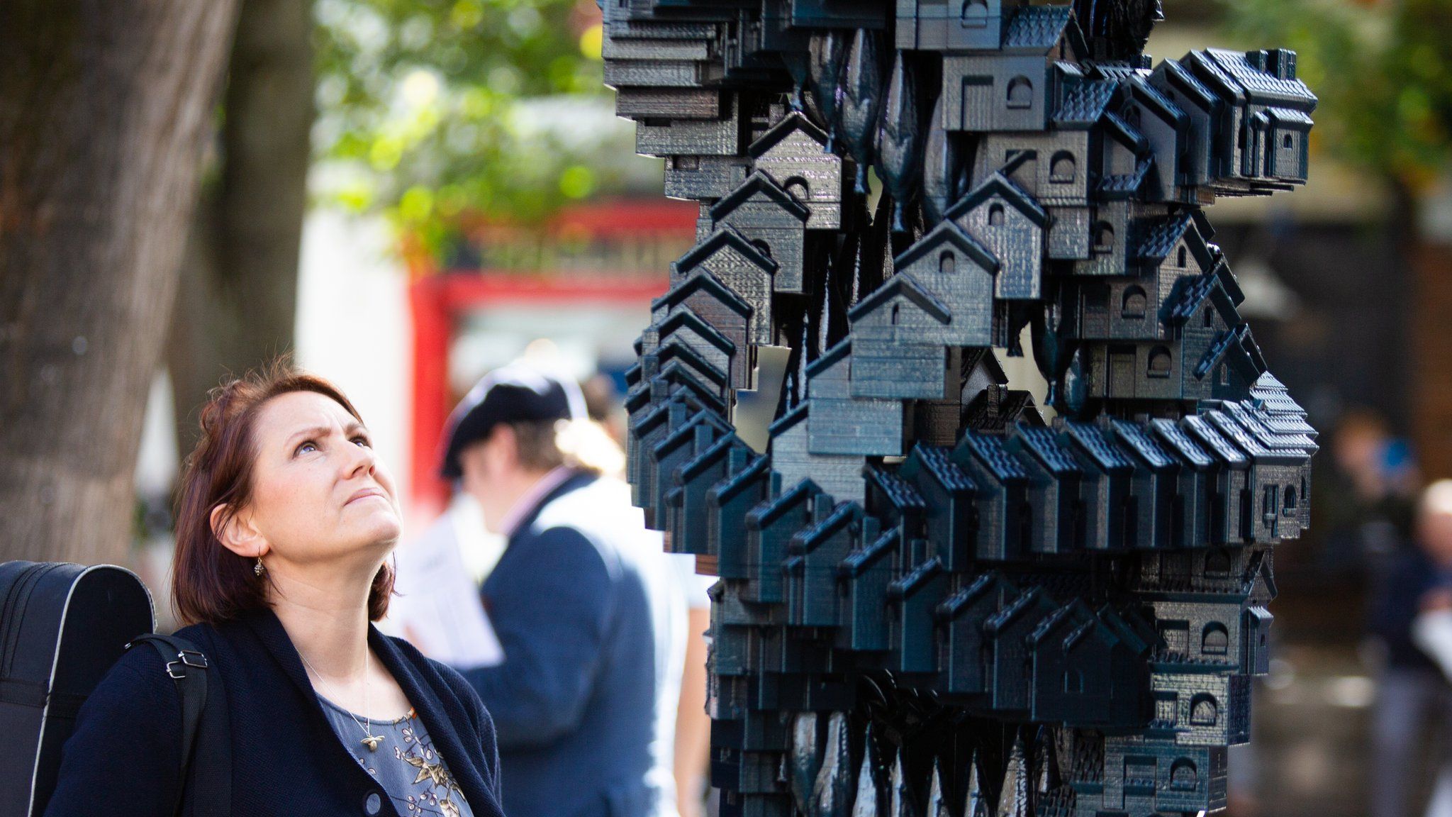 Woman looking at Matthew Plummer Fernandez's Token Homes sculpture