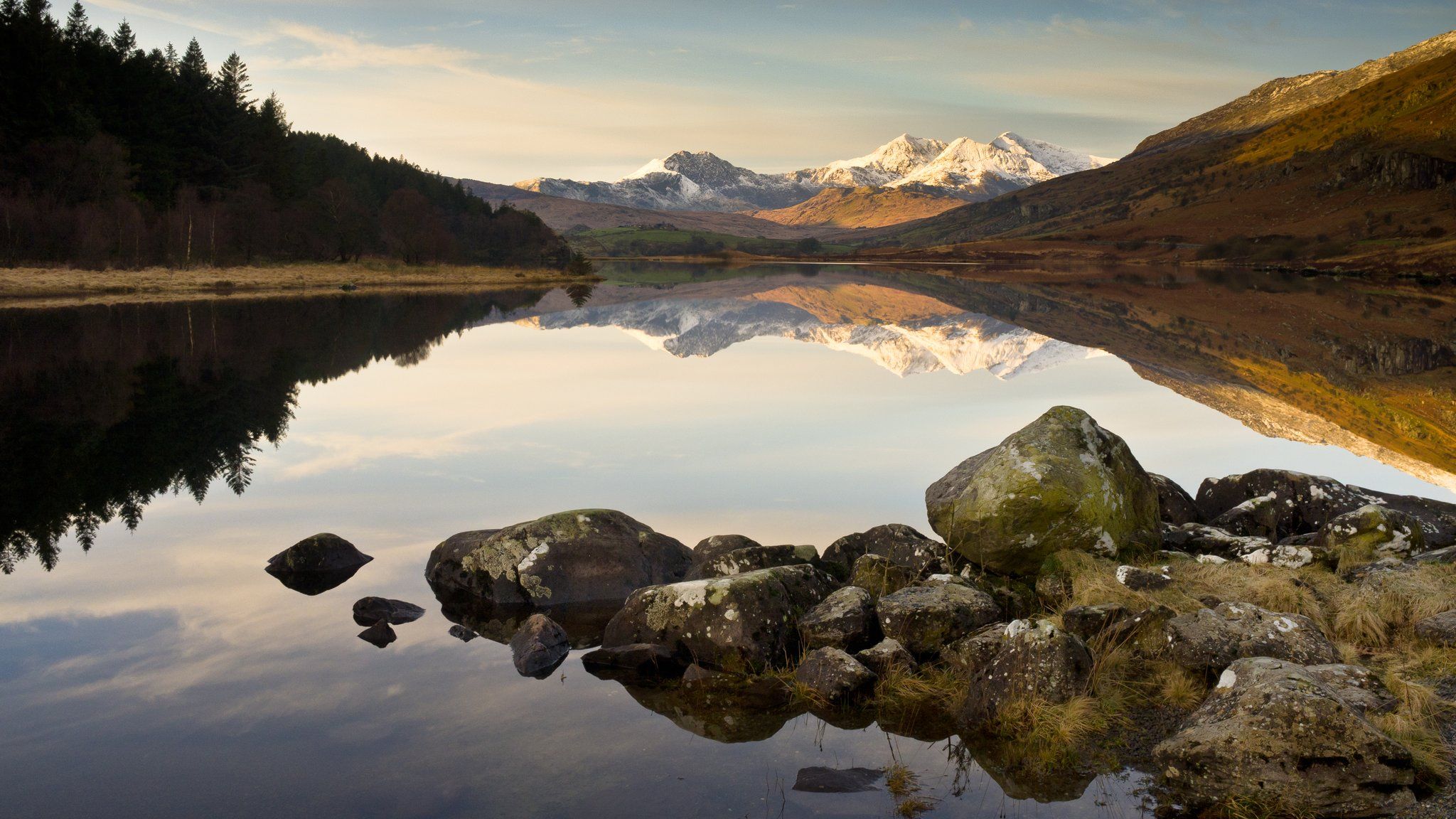 View of Snowdon Horseshoe with Llyn Mymbyr reflection on water in Snowdonia on winter morning