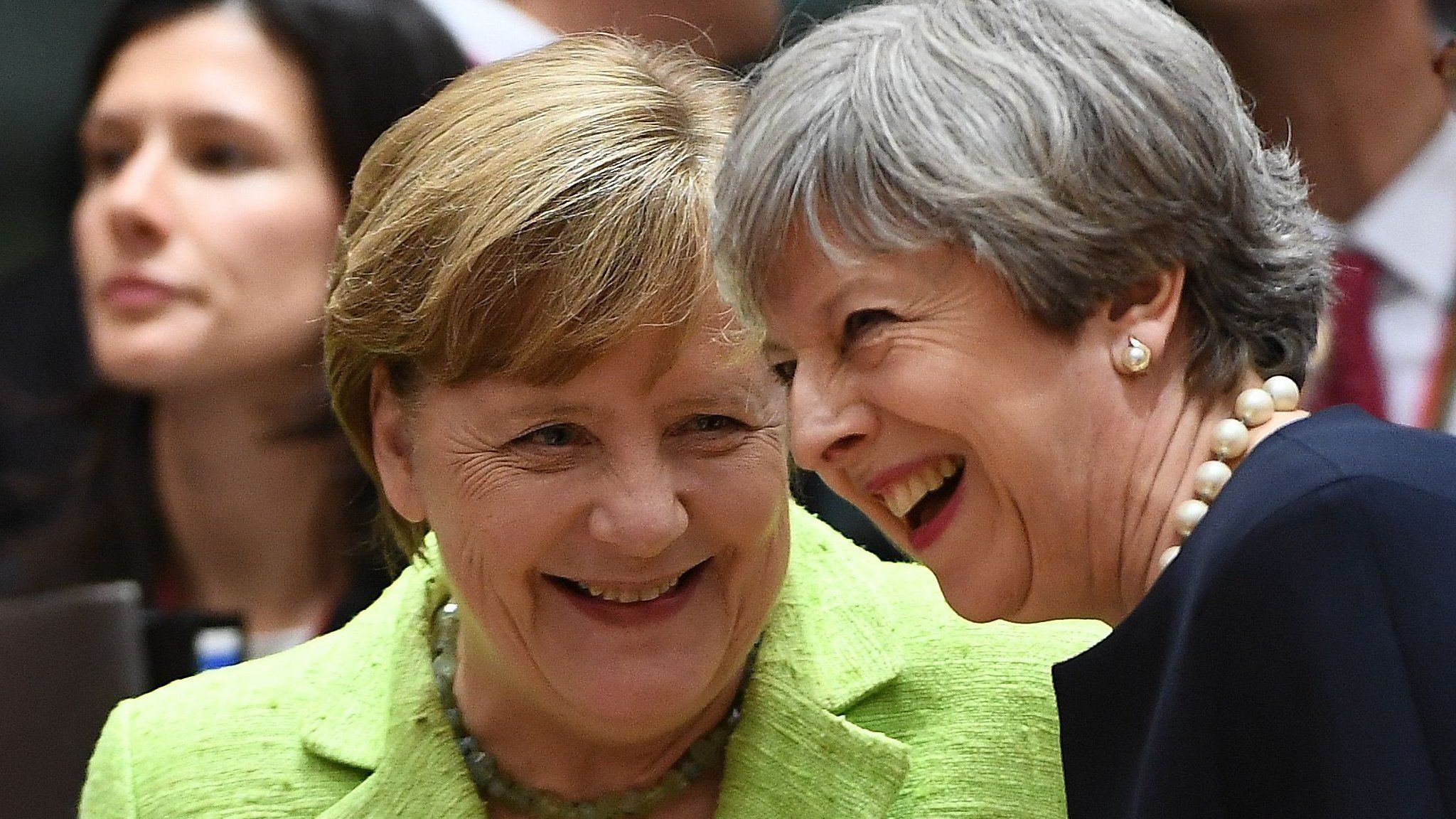 Theresa May (R) laughs as she talks with German Chancellor Angela Merkel at an EU leaders summit in Brussels, on June 22, 2017