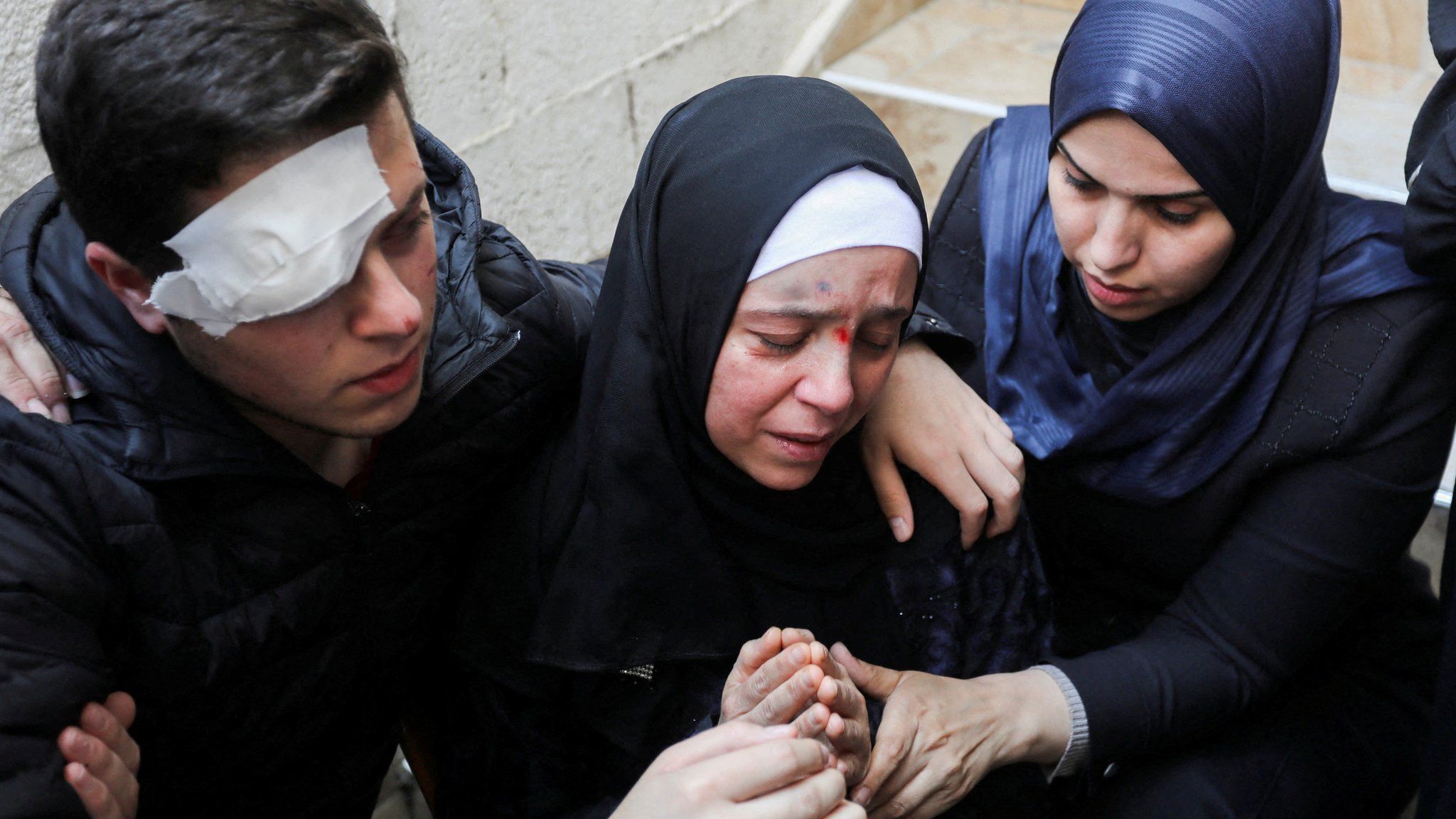 Injured relatives of an Islamic Jihad commander killed in Israeli strike react during his funeral in Gaza City (9 May 2023)
