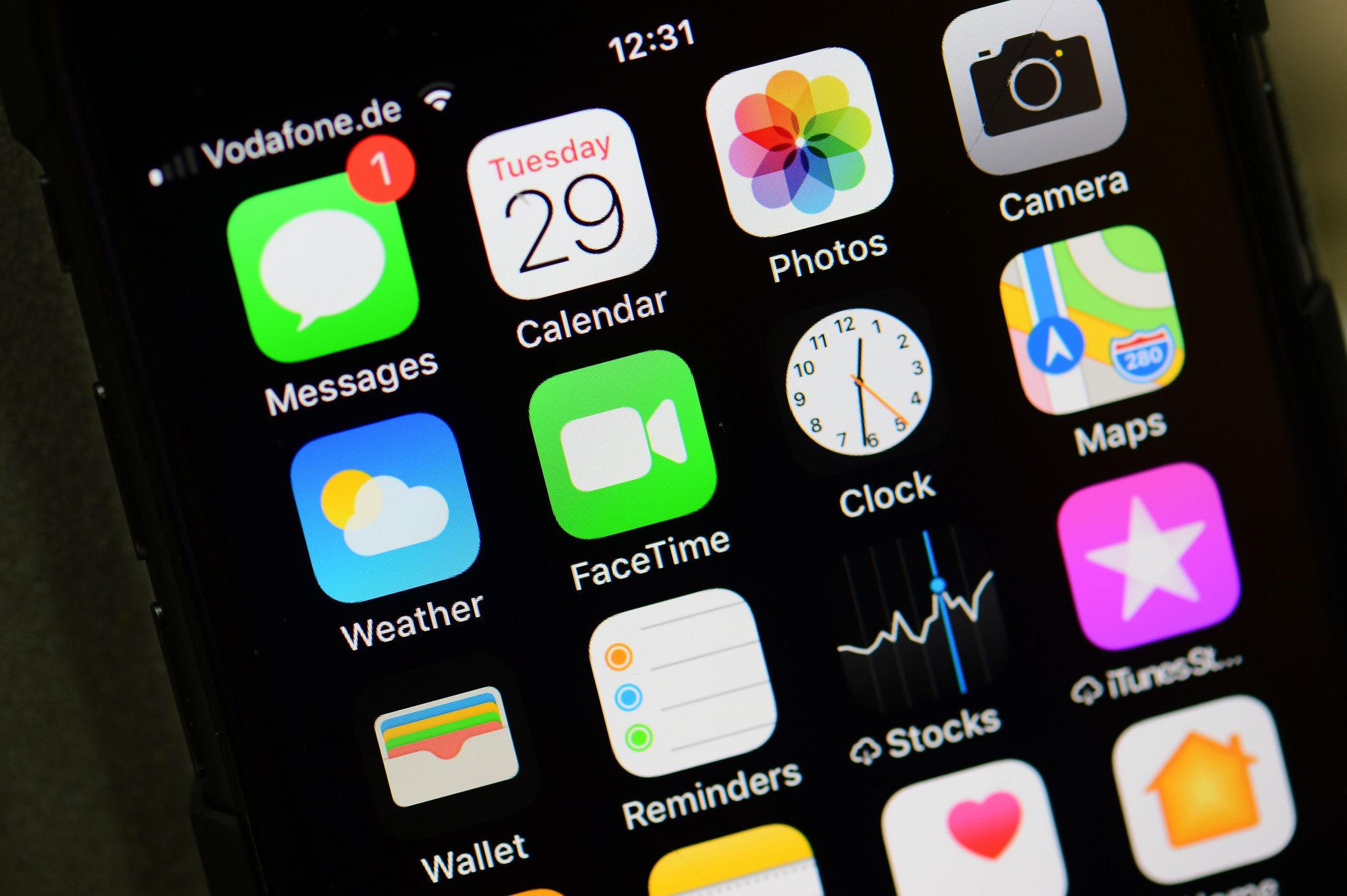 An iPhone home screen is pictured showing its many apps