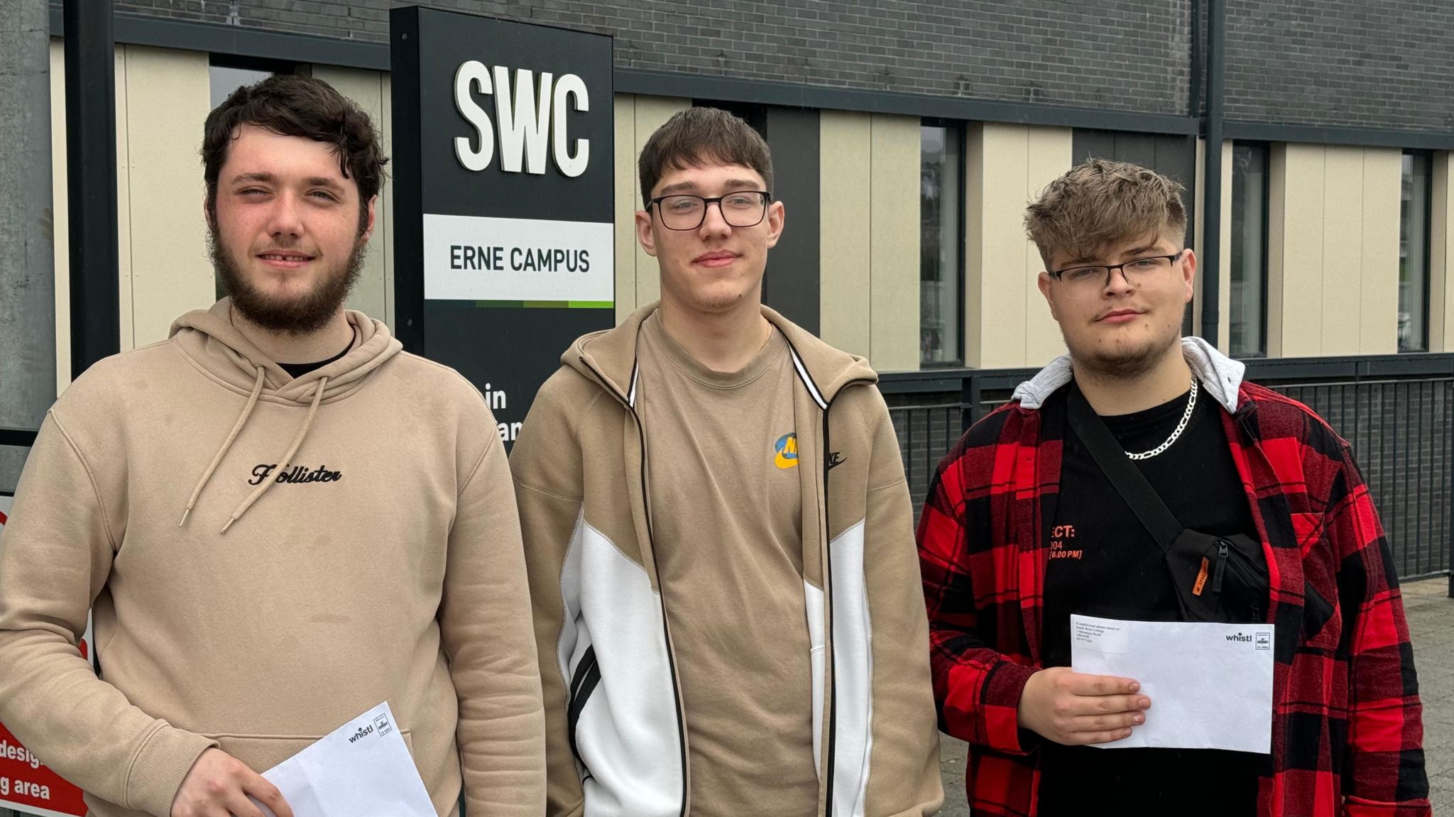 BTEC SW College Enniskillen IT Diploma students Kian Cassidy, Aleksander Zmuda and Oliver Piech. Kian is wearing a brown hood and has dark hair and a dark beard. Aleksander is wearing a brown zipped hoodie and has brown hair and glasses, Oliver is wearing red and black checked hoodie, and he has light brown hair and glasses.