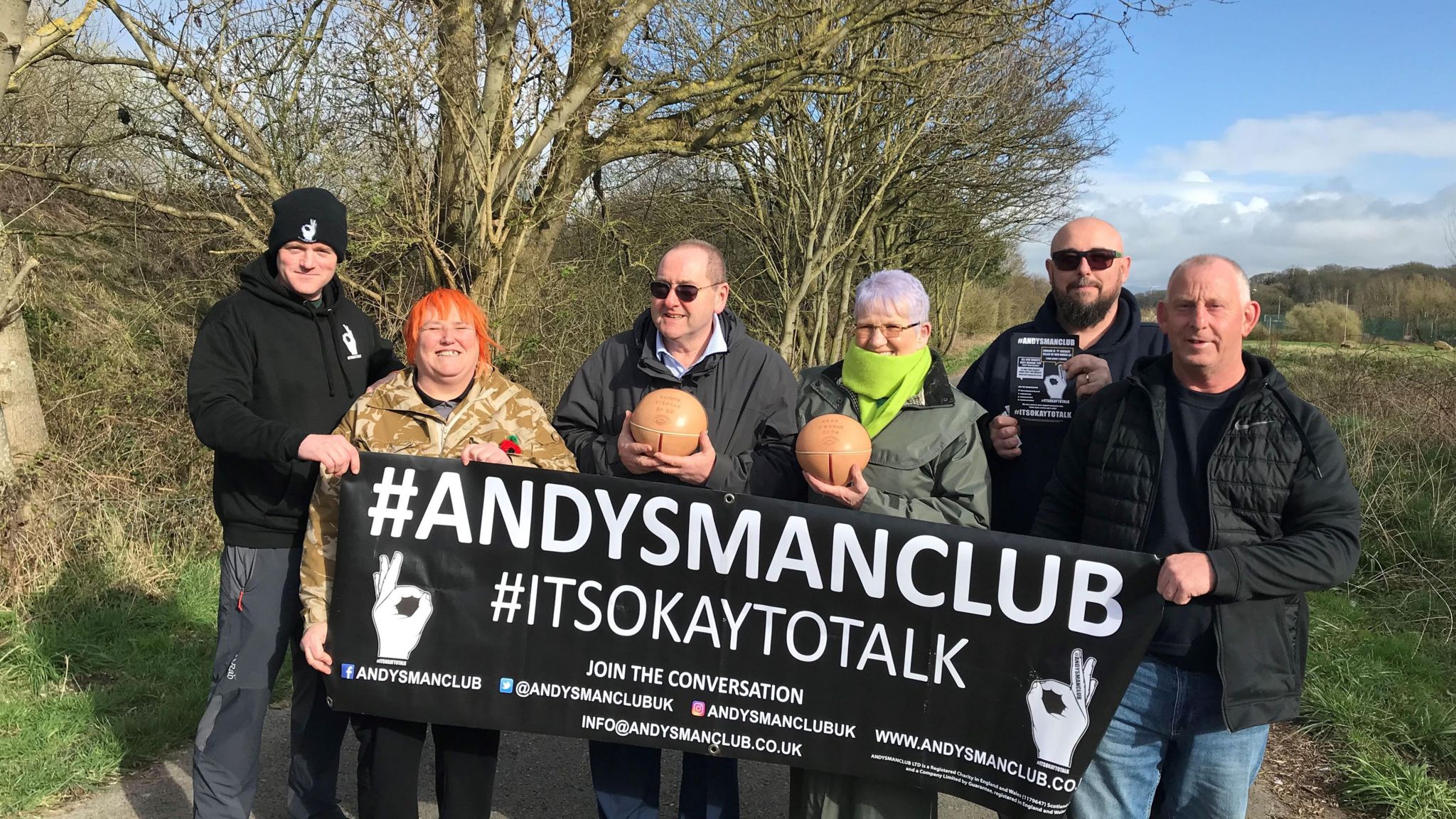 Players and supporters holding the Andy's Man Club banner