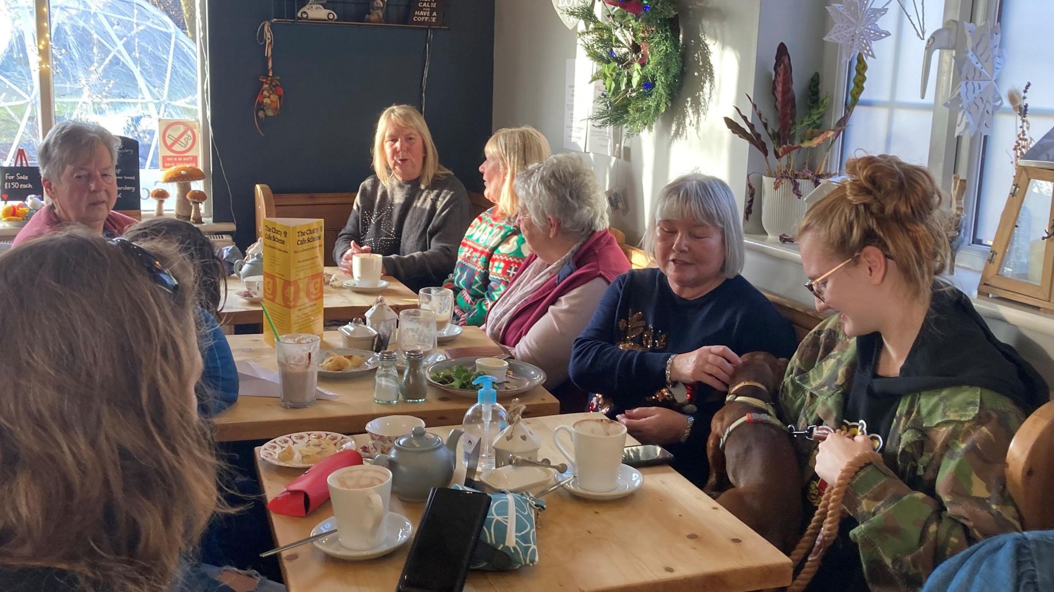 A group of people sat around tables in a cafe