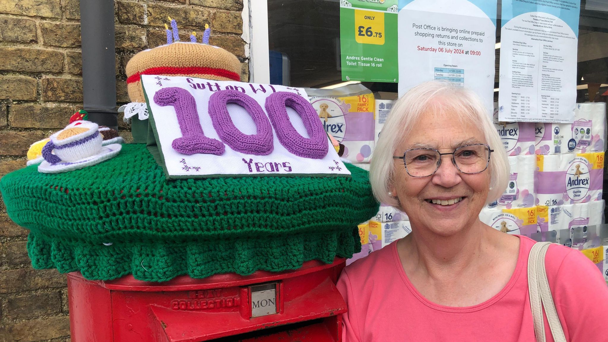 Heather Roberts with the Sutton WI 100 years topper on a post box