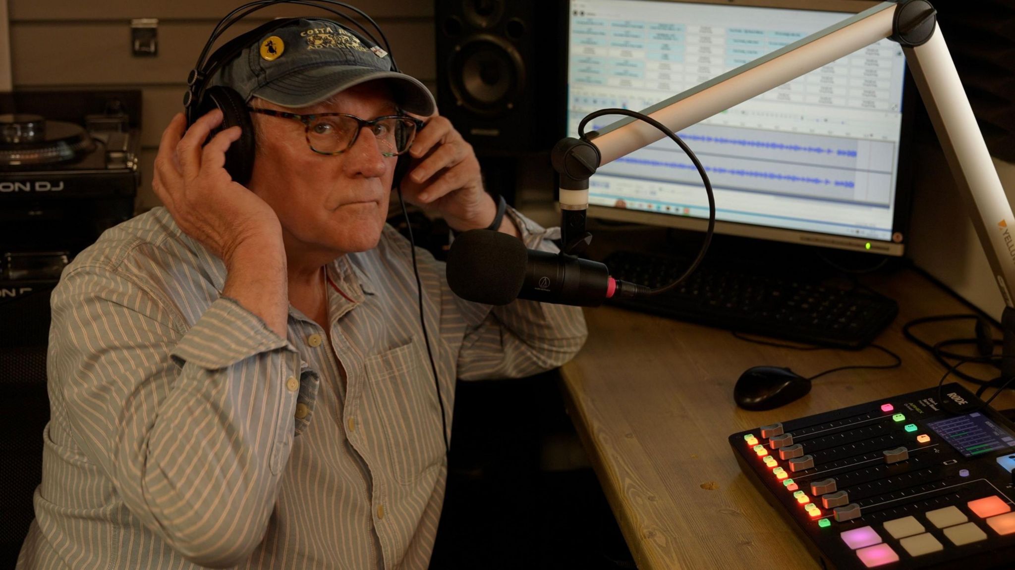 Lee Ackers wearing headphones in the Deal Community Radio Station studio