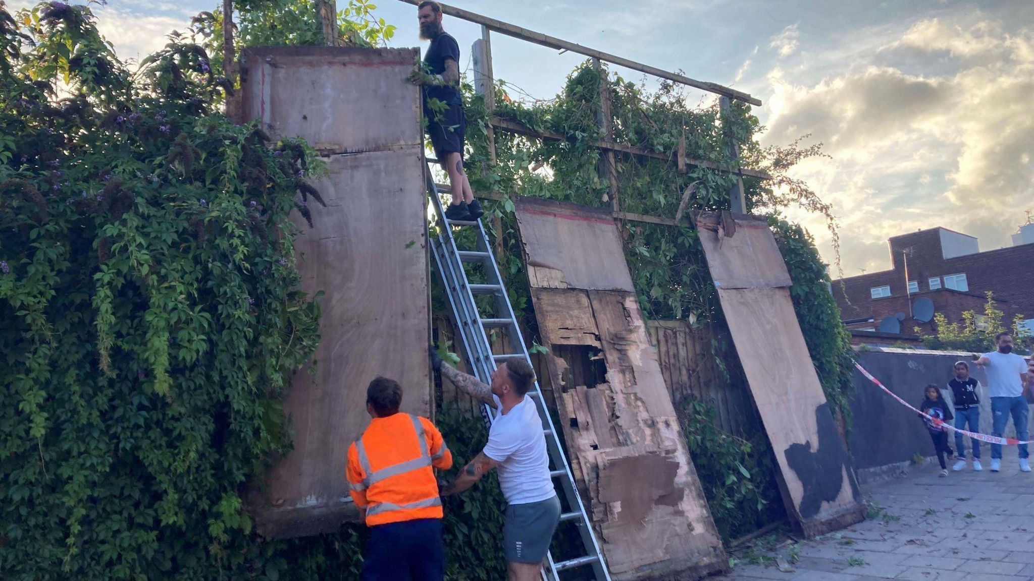 Contractors dismantling a billboard in Cricklewood adorned with Banky's stretching cat 