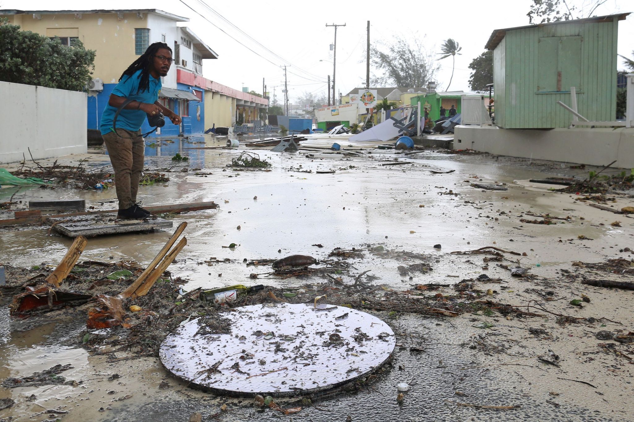 A man walks along a debris-filled street