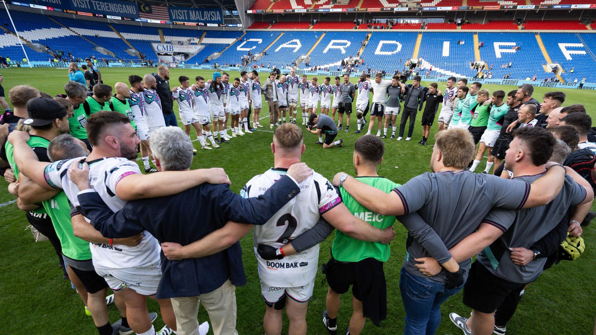 Ospreys players and squad celebrate victory at the Cardiff City Stadium