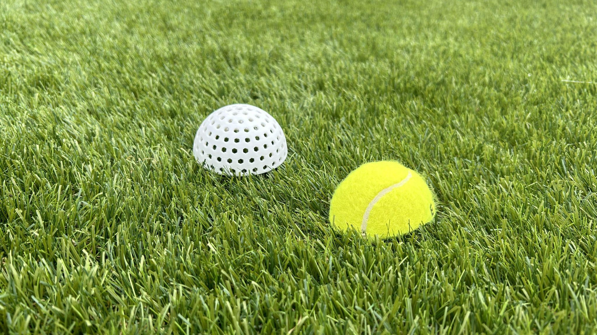 One of the concept balls showing the polymer outer shell with holes compared to a standard tennis ball