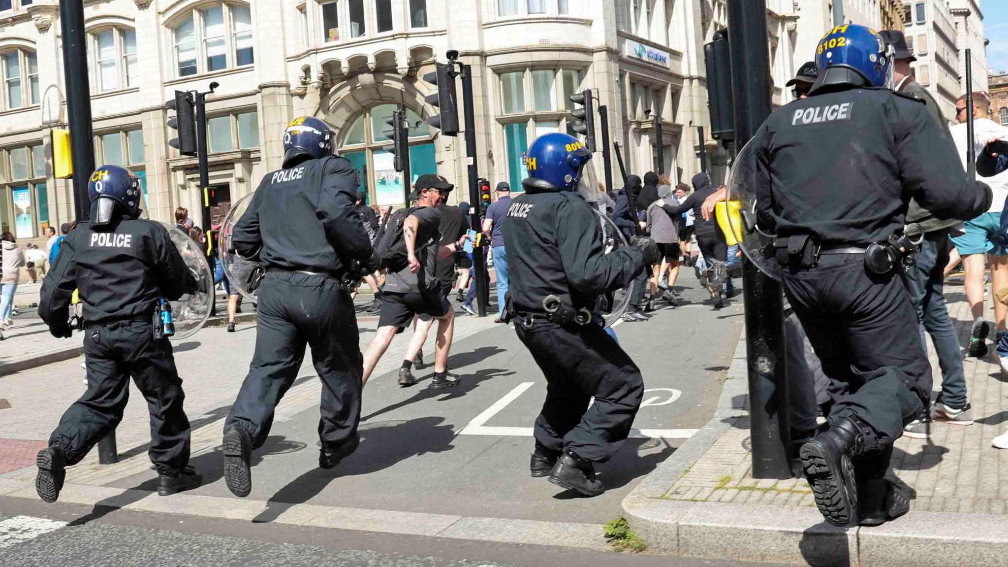 Riot officers charge at protesters on the Pier Head