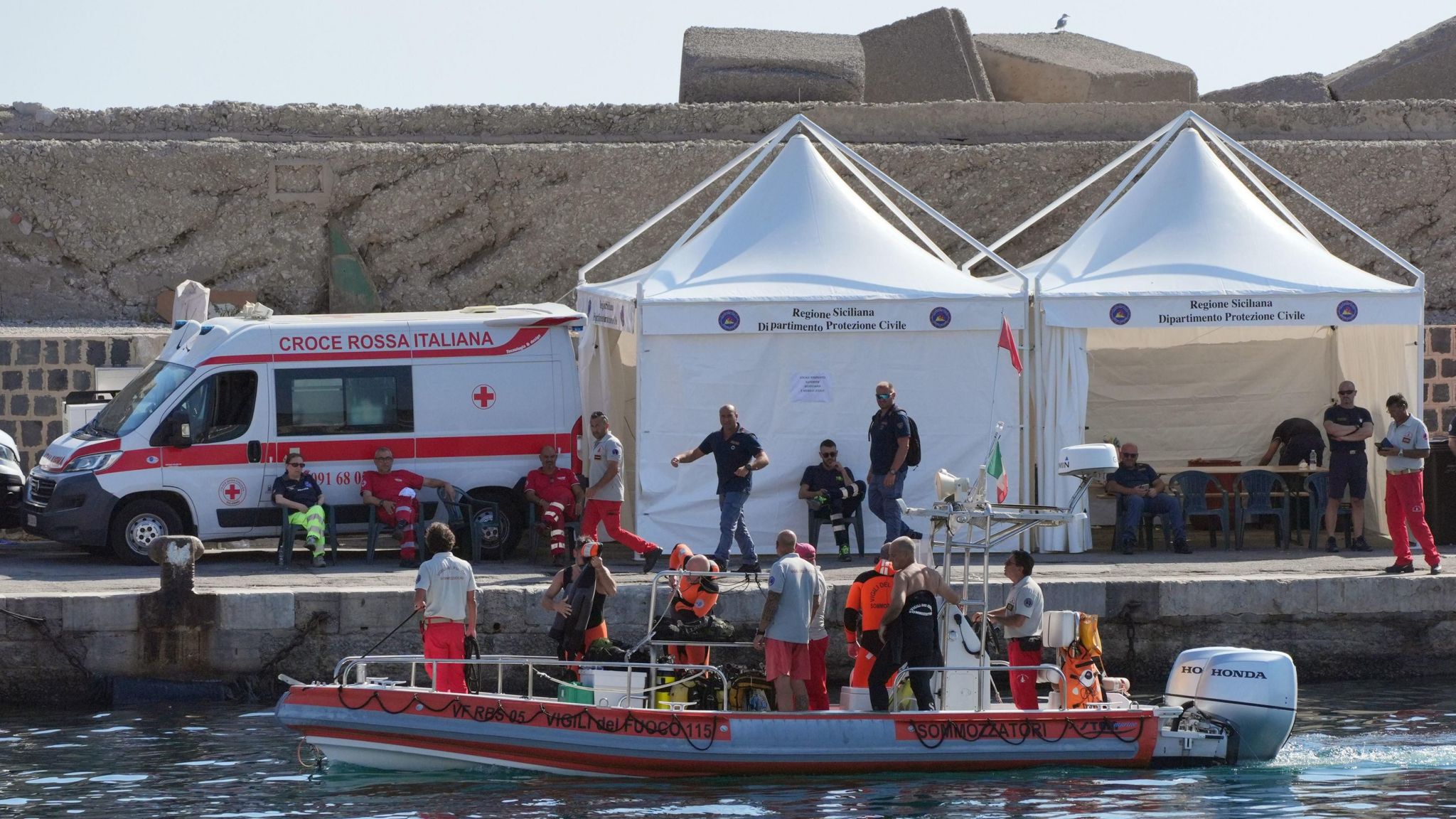 An Italian fire service dive team return to port on the fifth day of the search and recovery operation