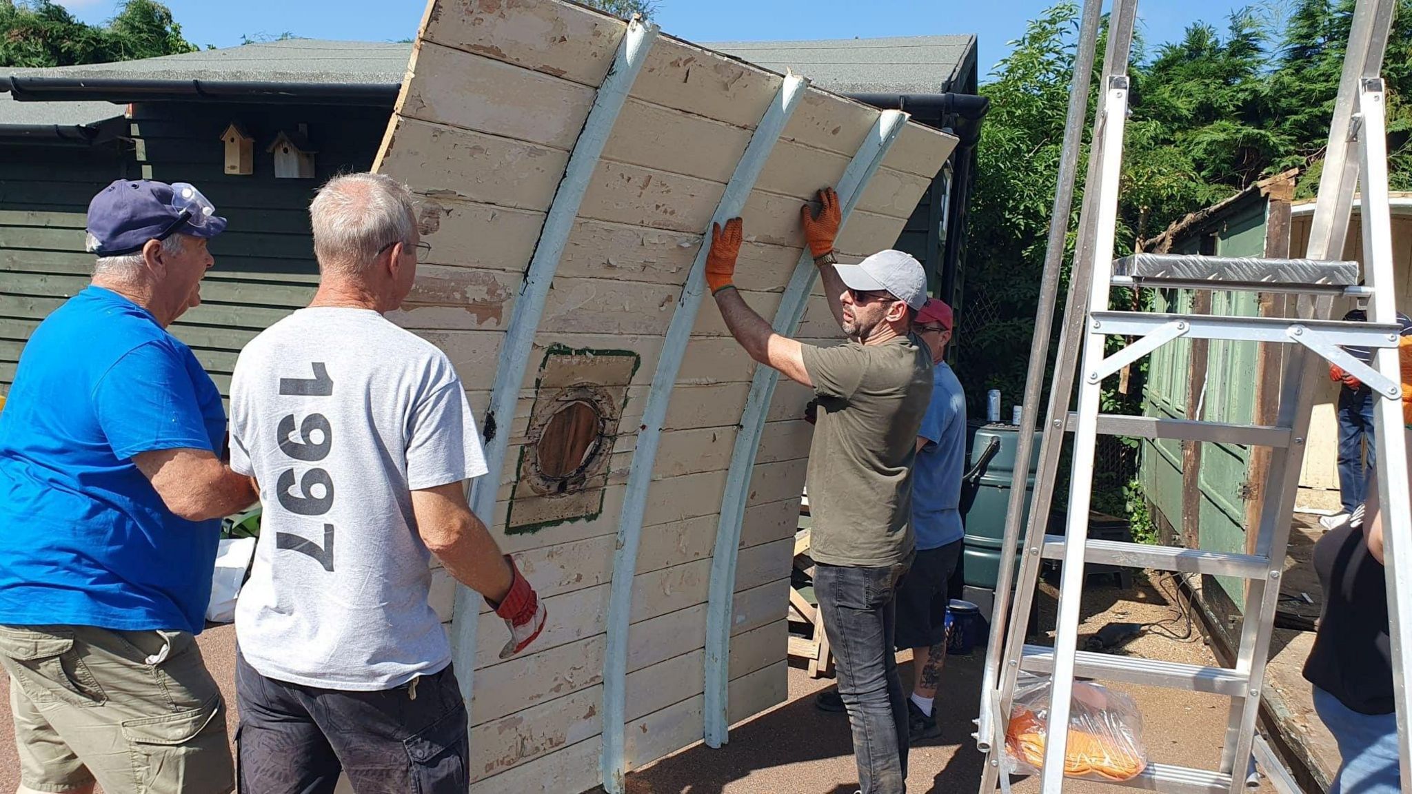 A group of people dismantling the railway carriage