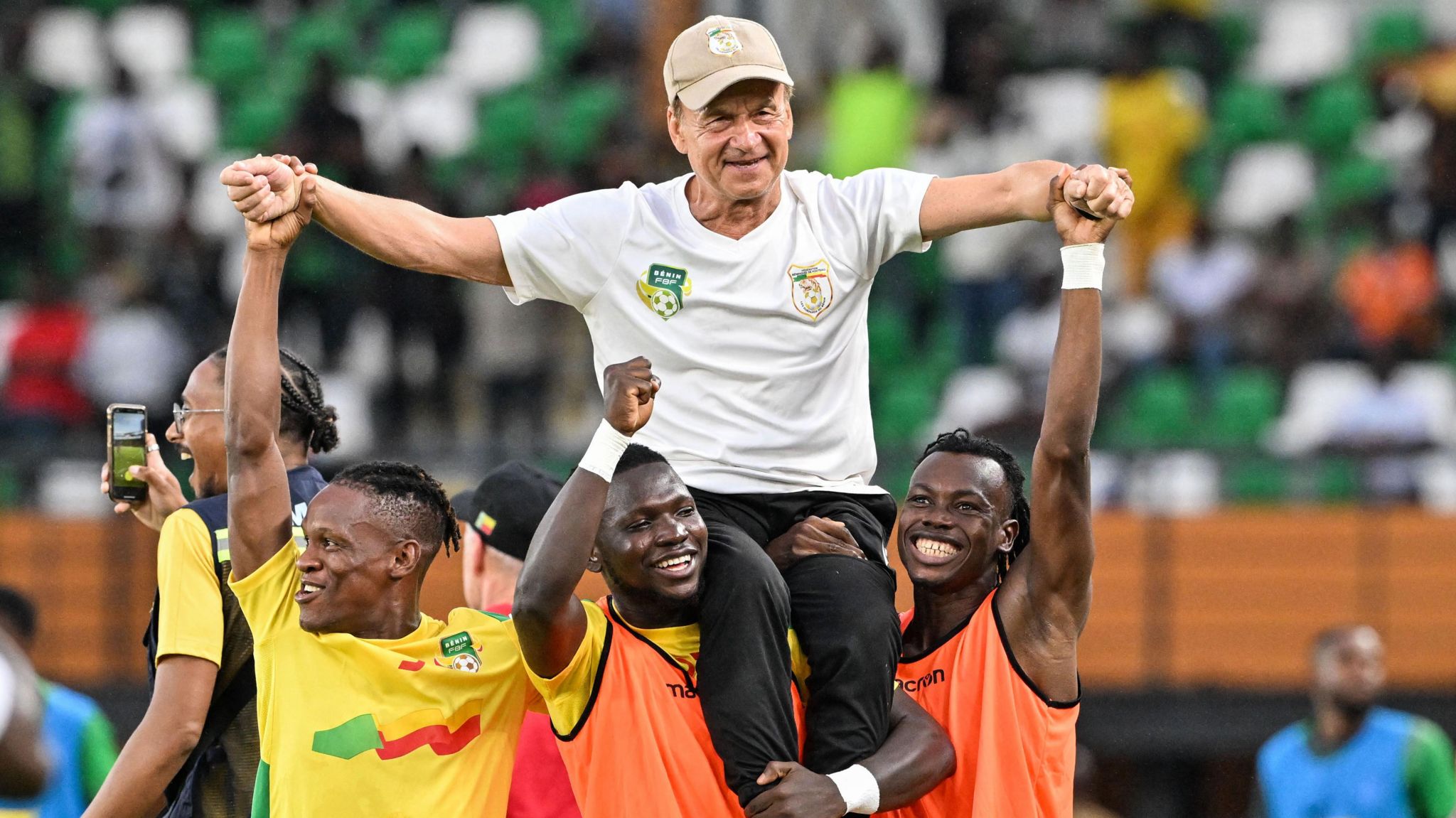 Benin coach Gernot Rohr is chaired onto the pitch by players after his side beat Nigeria