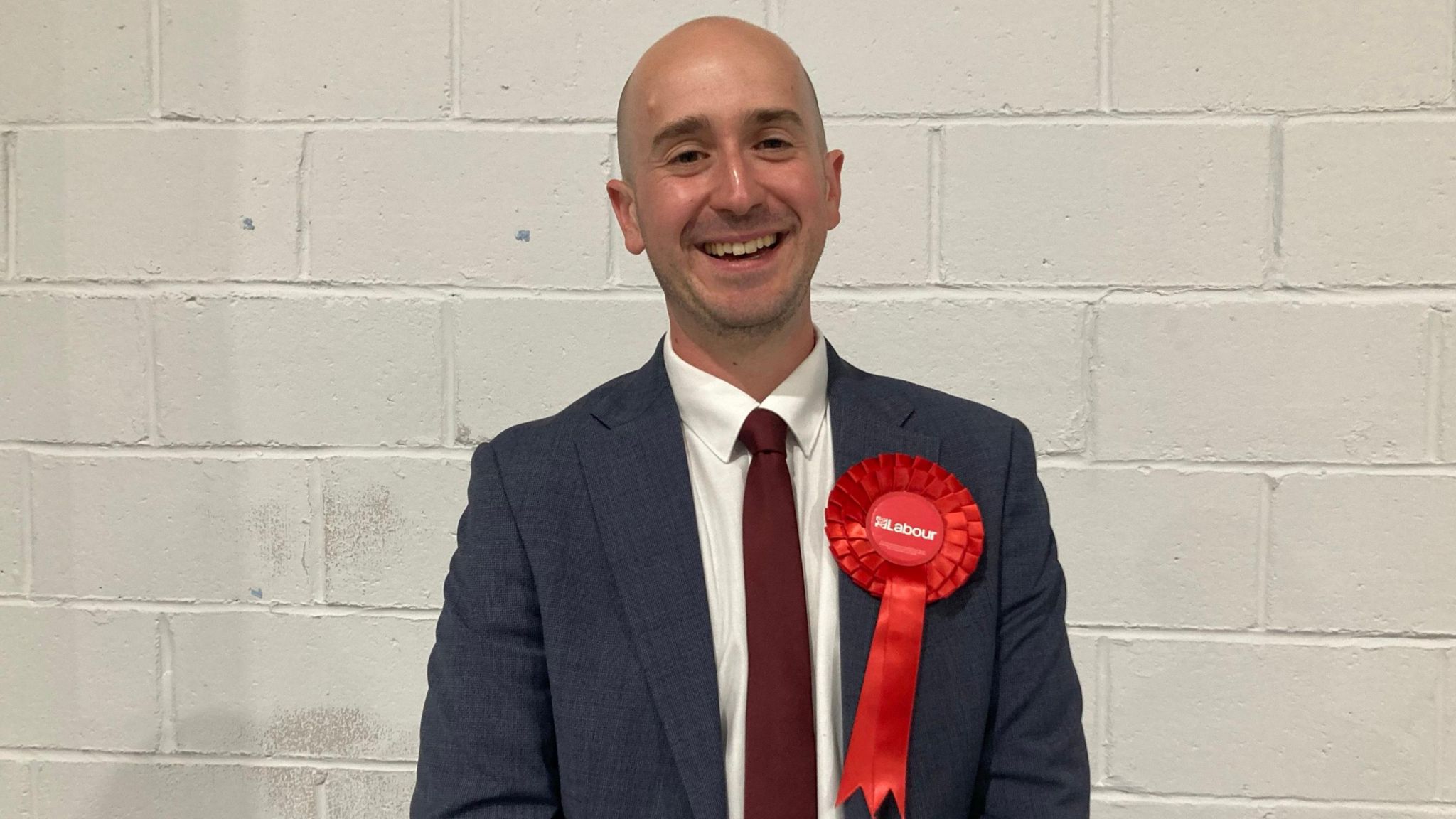 Ben Goldsborough wearing a red rosette