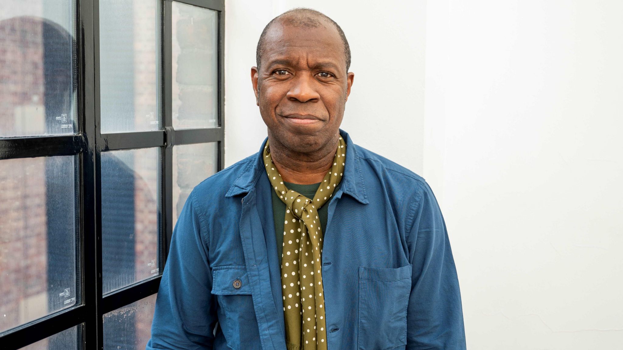 Clive Myrie pictured in blue shirt and polker dot scarf