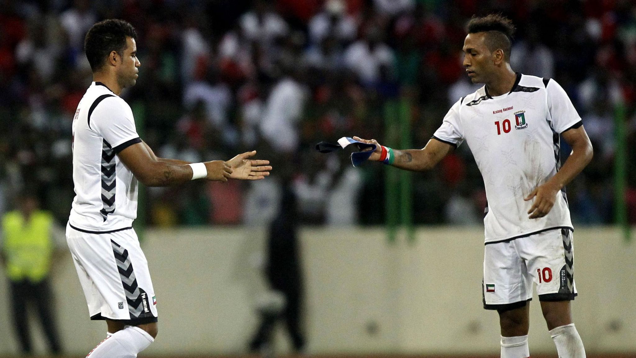 Emilio Nsue hands the captain's armband to Rodolfo Bodipo as Equatorial Guinea play Spain in November 2013