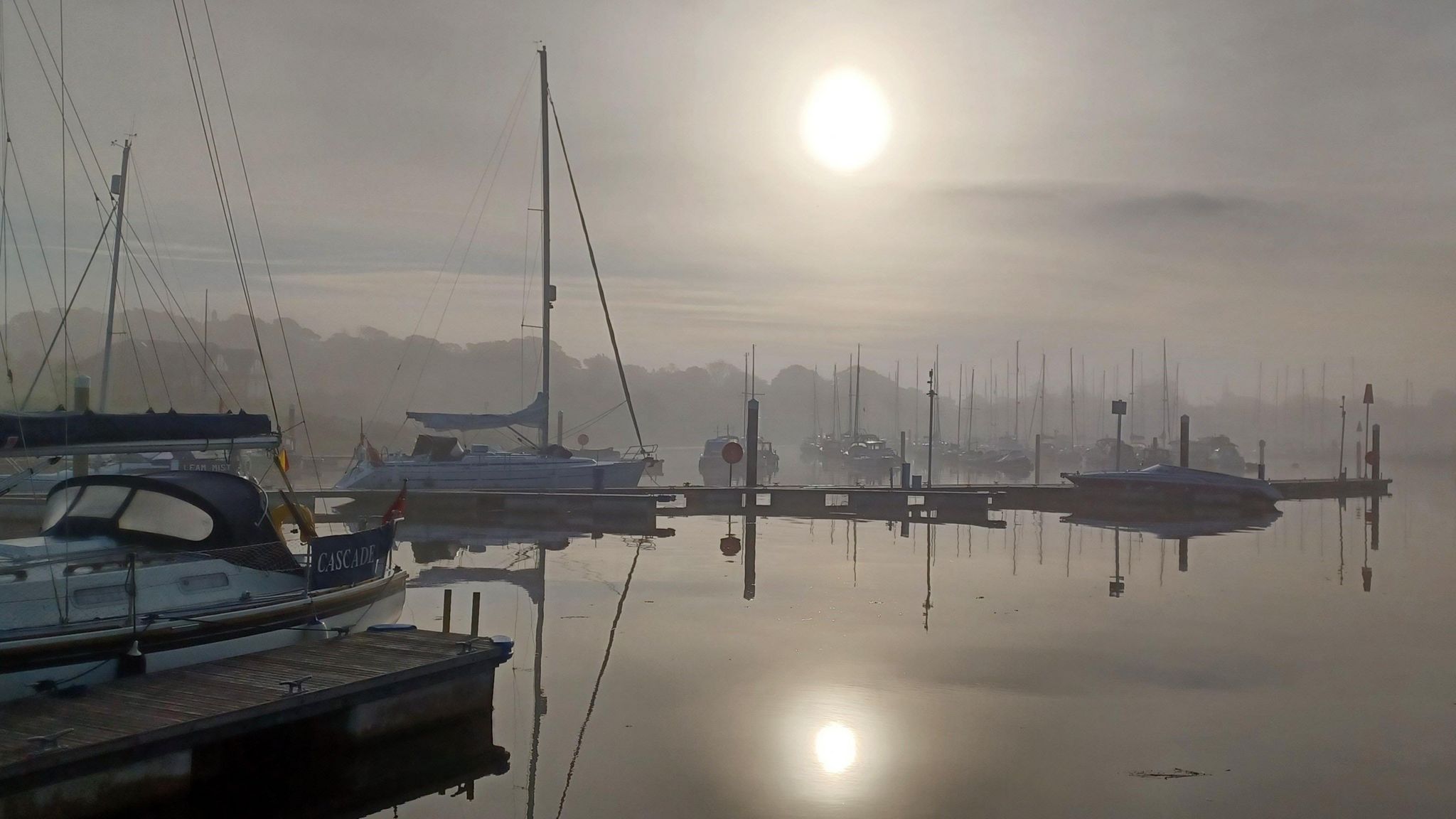 MONDAY - Misty sunlight over Lymington Quay, showing several boats and yachts