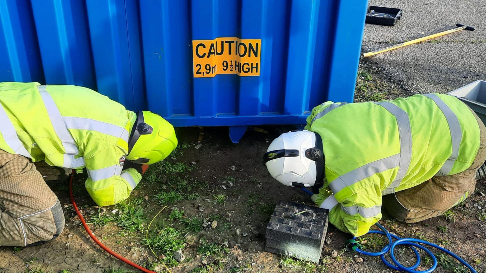 Firefighters lifting a container