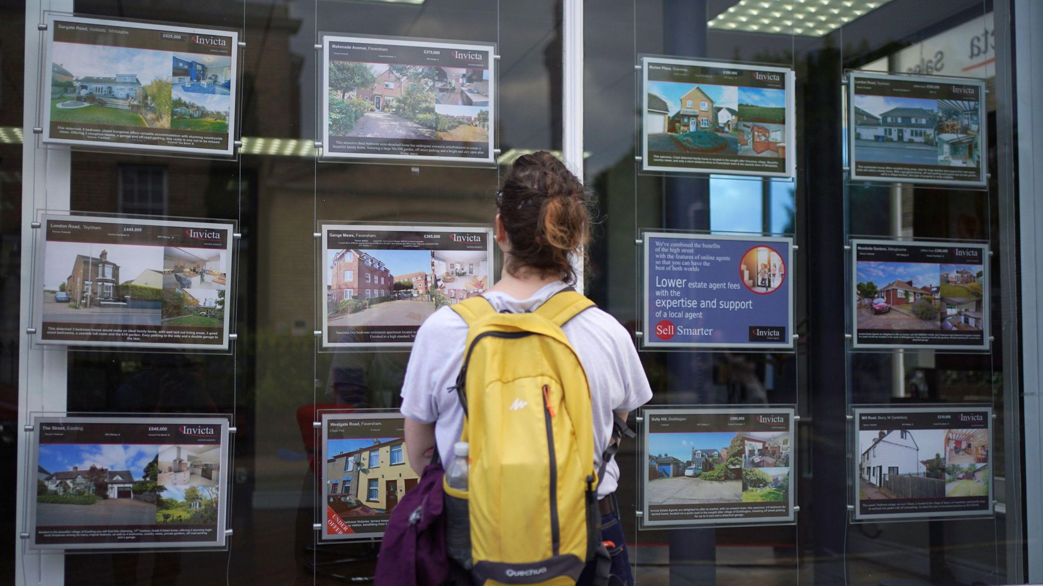 A woman looking in an estate agent window