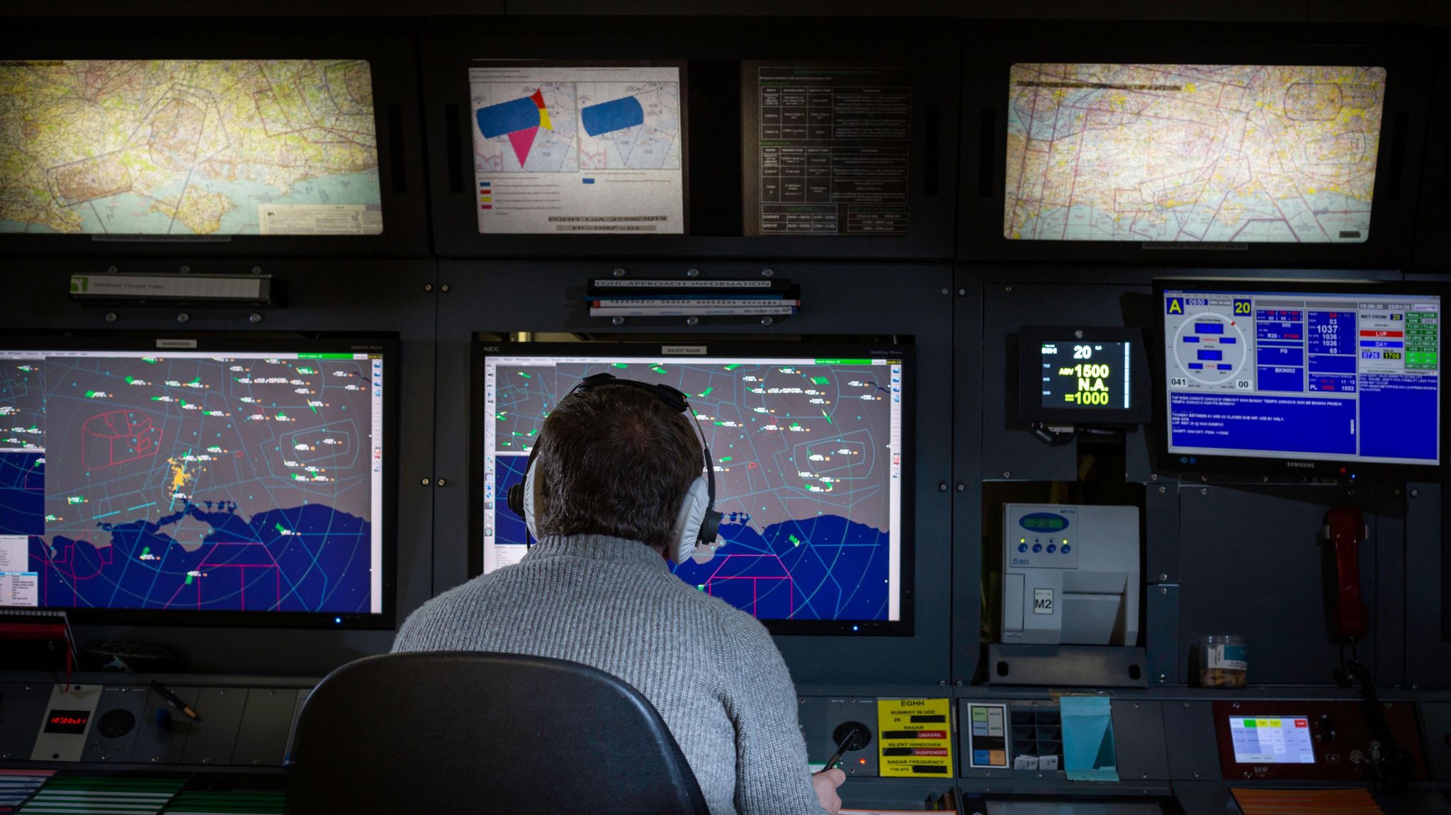 An air traffic control officer looking at radar screens
