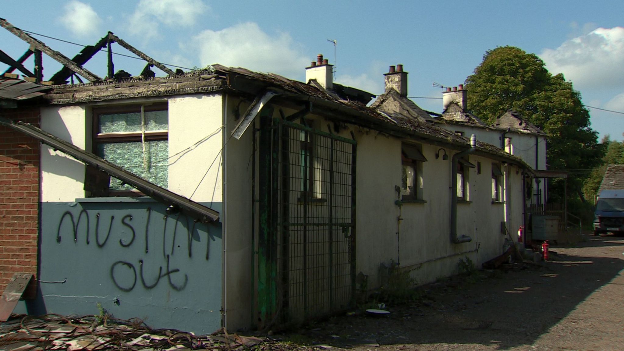 Fire damaged exterior of a bar with muslims out spray painted on 