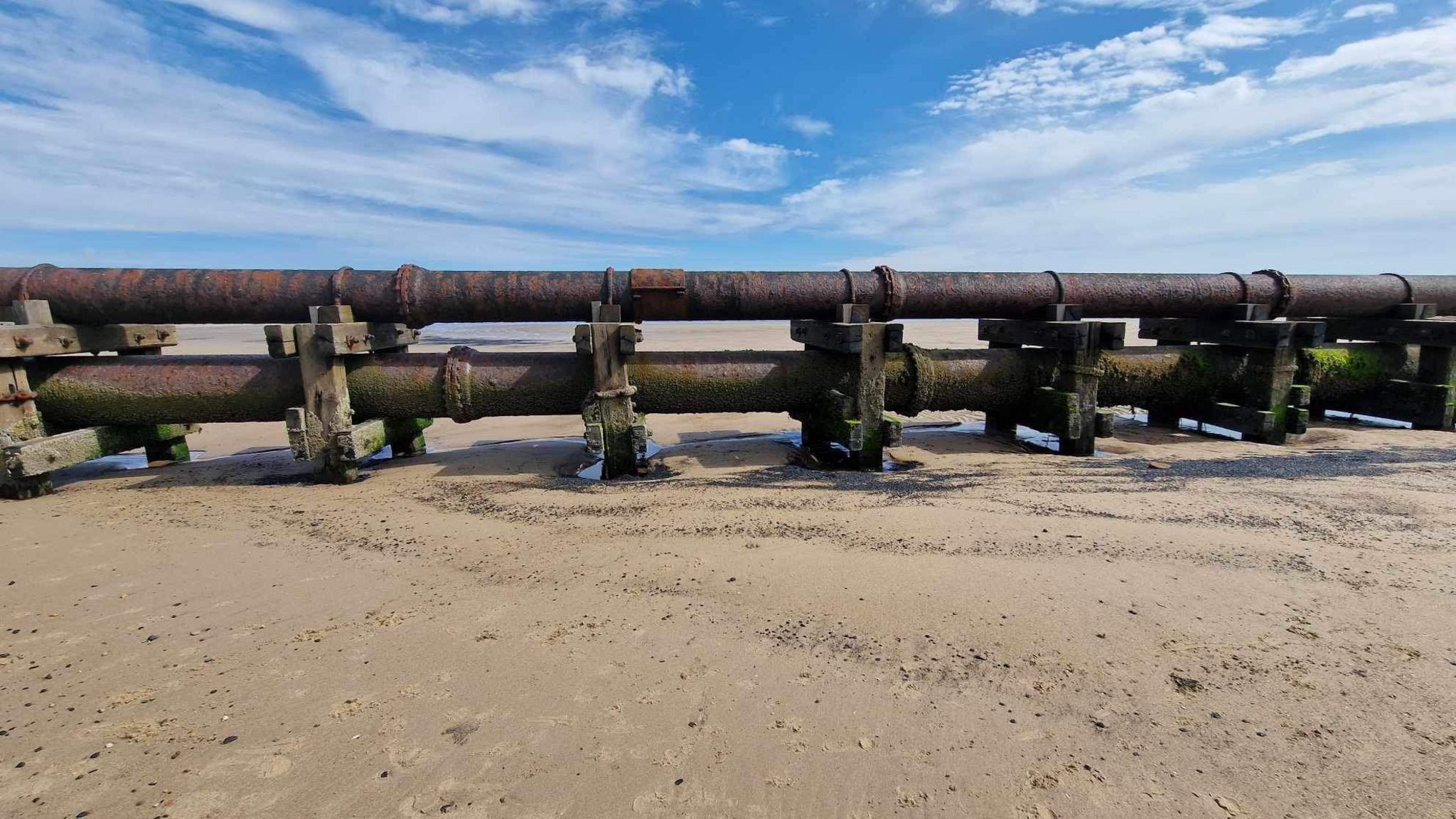 A big pipe stretching out across the beach  