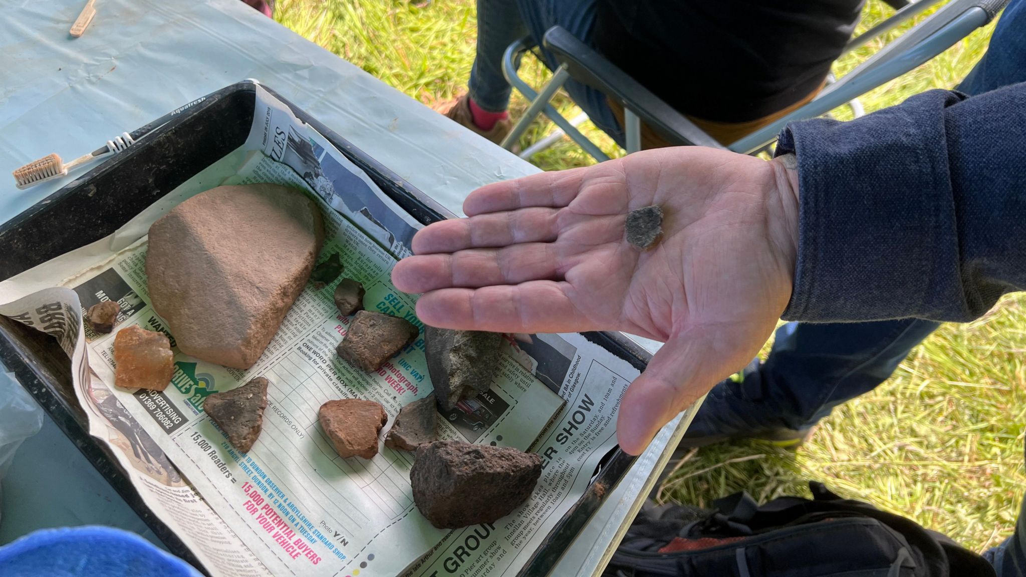 Someone showing off rocks found in digs