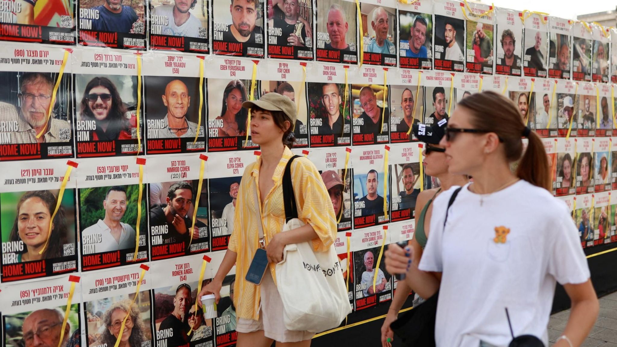 People walk past posters in Tel Aviv, Israel, showing Israelis held hostage in Gaza by Hamas (13 August 2024)