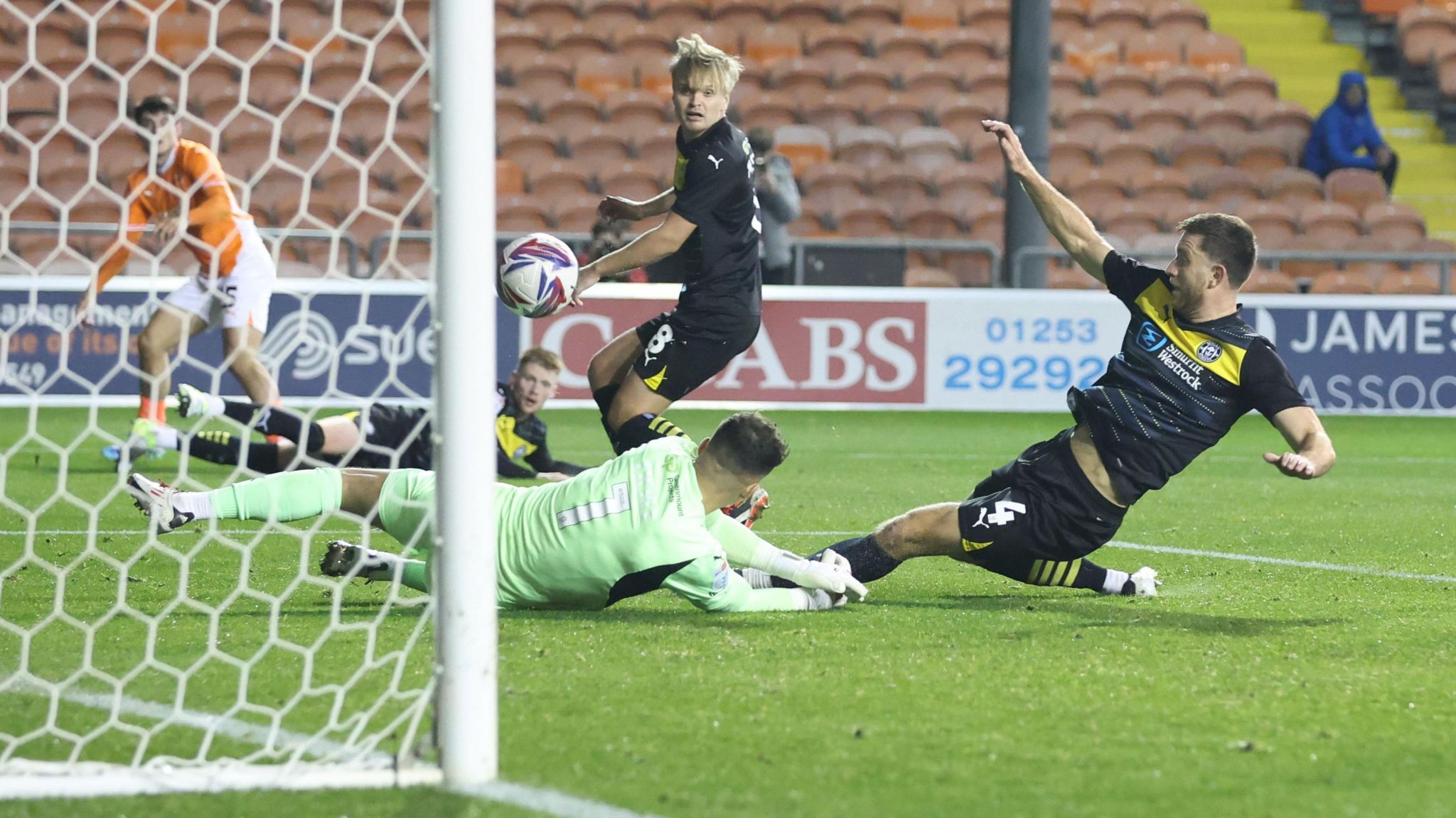 Wigan defender Will Aimson scores a late own goal against Blackpool.