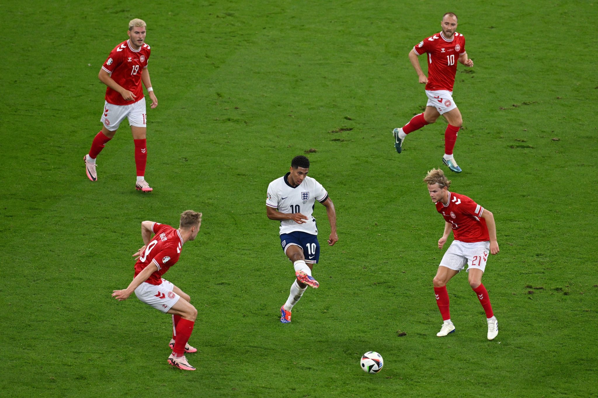 England's Jude Bellingham, surrounded by four Denmark players, passes the ball