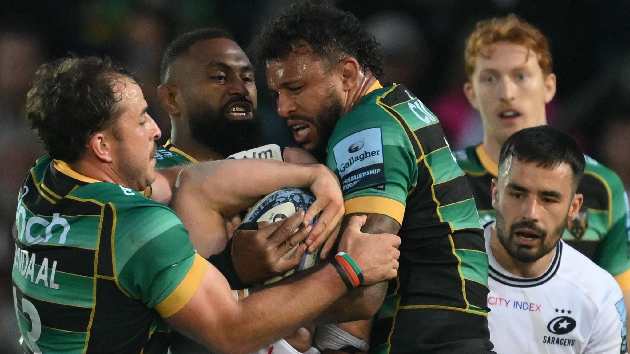 Courtney Lawes (centre) and Burger Odendaal hold up Theo Dan in the final moments against Saracens