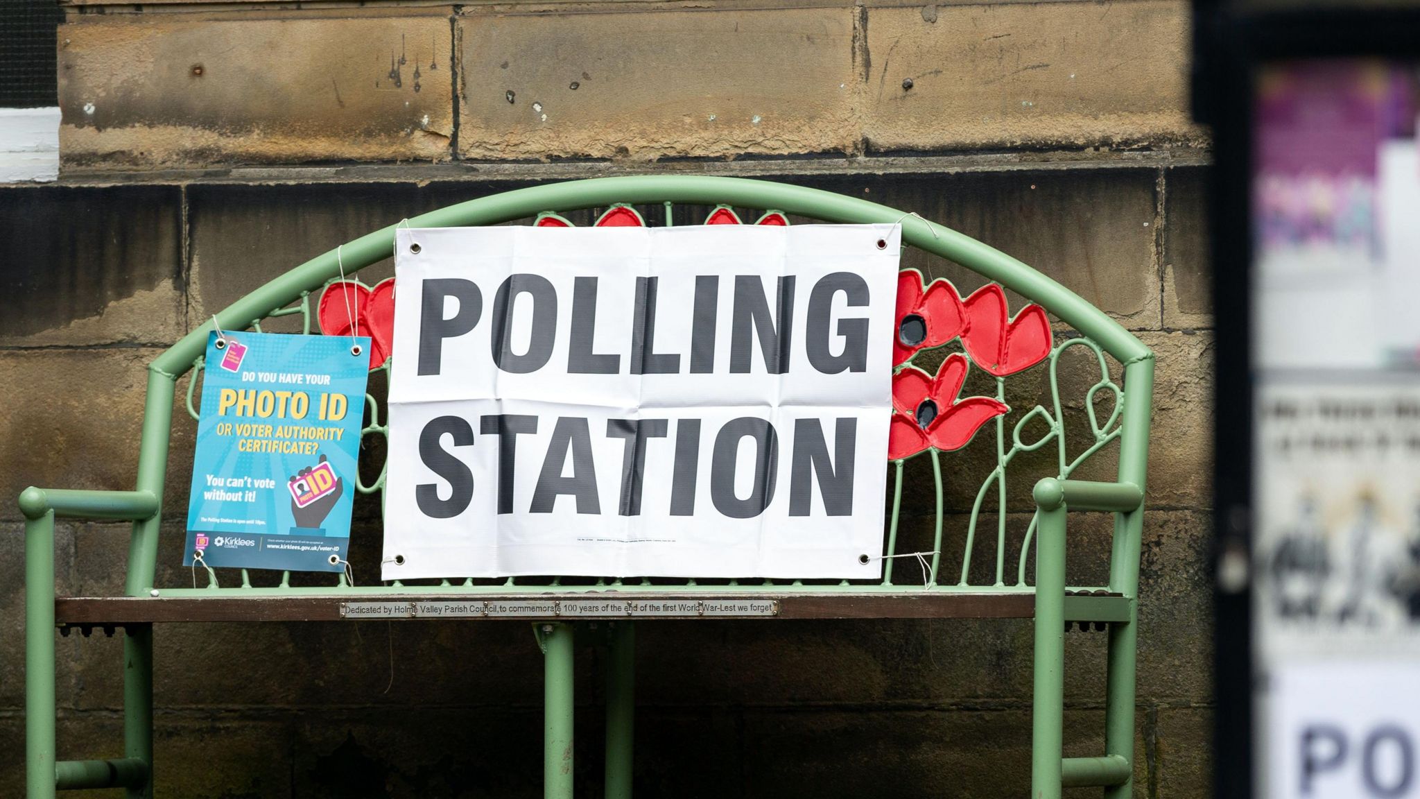 A poster reminds voters to bring photo ID at a polling station