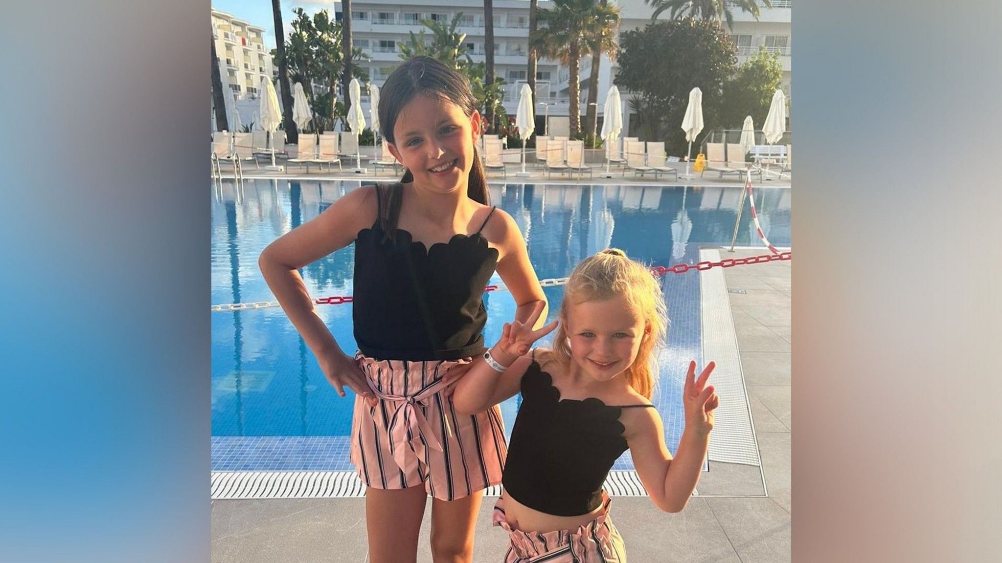 Rubie Morgan-Roller and Lillie Morgan-Roller smiling in front of a swimming pool