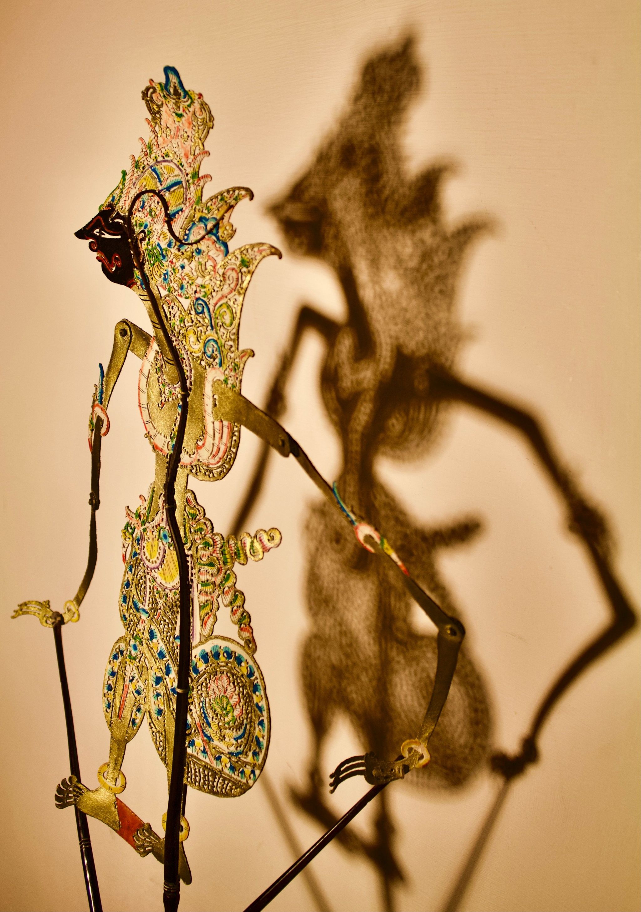 An Indonesian shadow puppet casting a shadow on the wall
