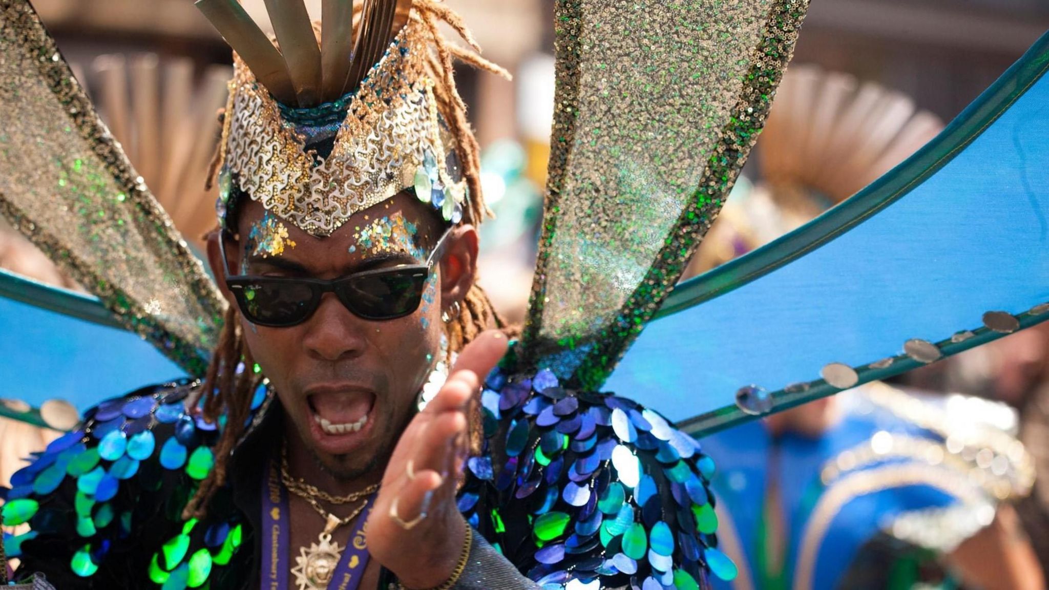 A carnival goer wearing blue sequin outfit and gold headband