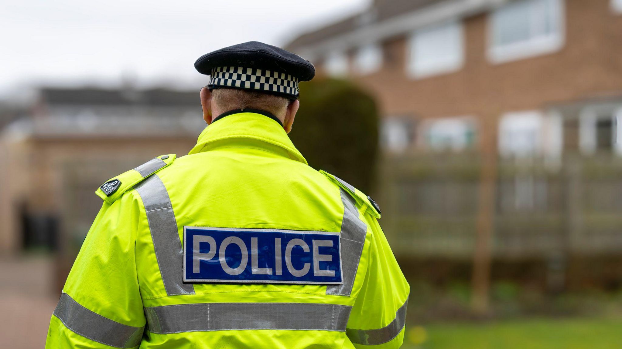 The back of a police officer wearing a hi-vis jacket 