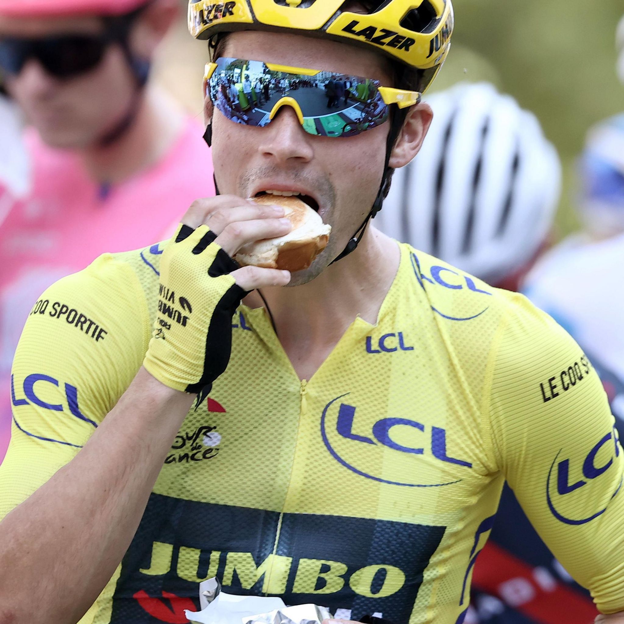 Primoz Roglic eats a sandwich on the Tour de France startline