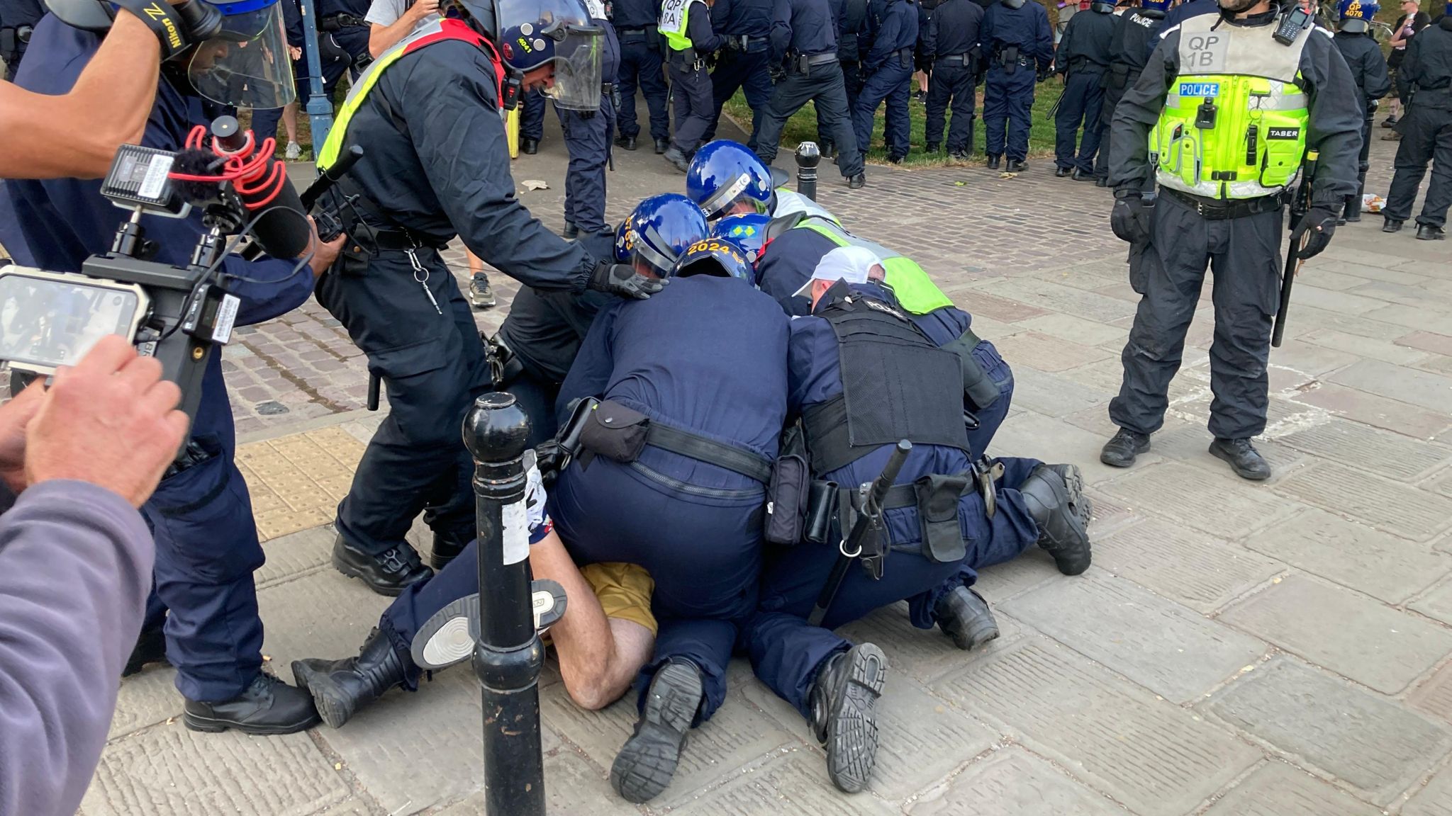 Police restraining a protestor on the ground in Bristol