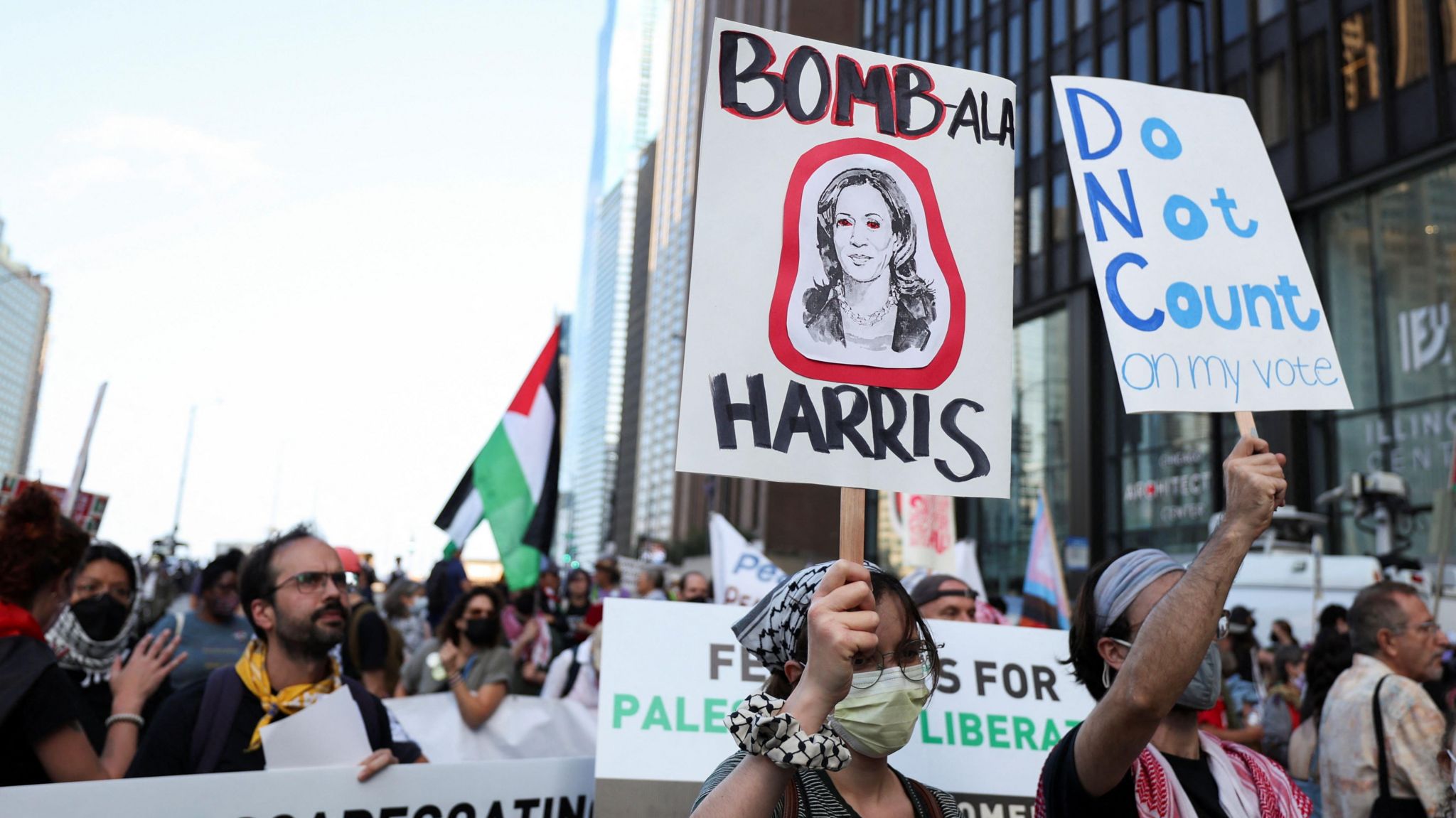 Protesters hold signs including "Bombala Harris"